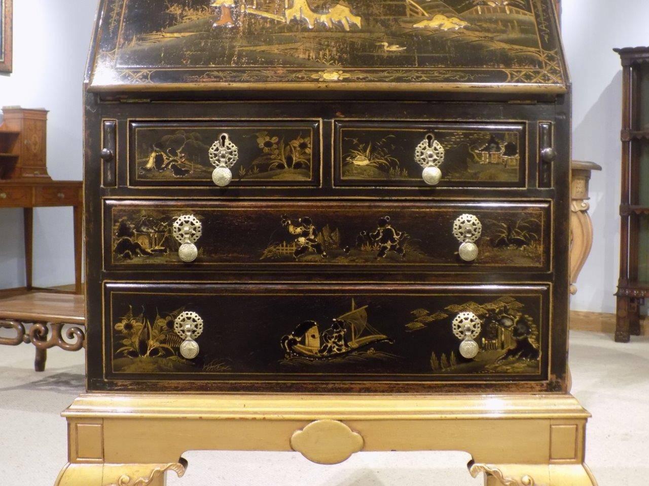 A chinoiserie lacquered Edwardian period bureau on stand. The bureau section having fine raised lacquered detail depicting Oriental every day life to the fall front, sides and drawer fronts. The bureau opening to reveal pigeon holes, shelves and a
