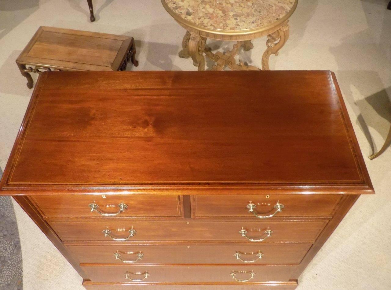 A beautiful mahogany inlaid Edwardian period antique chest of drawers. Having a solid mahogany rectangular top with line inlaid detail and crossbanded in rosewood, above the arrangement of two short and three long rectangular mahogany lined drawers