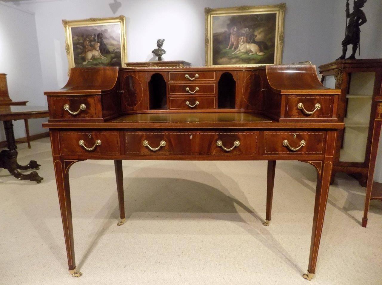 A fine quality Edwardian period flamed mahogany carlton house desk. The upper section with a brass shaped gallery above the mahogany curved top with flamed mahogany shaped panels and having an inset green blind and gilt tooled leather writing