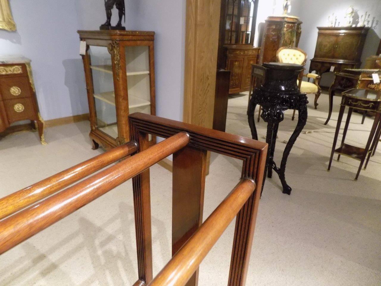 A find quality mahogany Edwardian period towel rail. With quadruple reeded moulding to the ends and with satinwood inlaid detail. Having five turned mahogany towel rails and raised on four turned mahogany feet undated by a plum pudding shelf.
