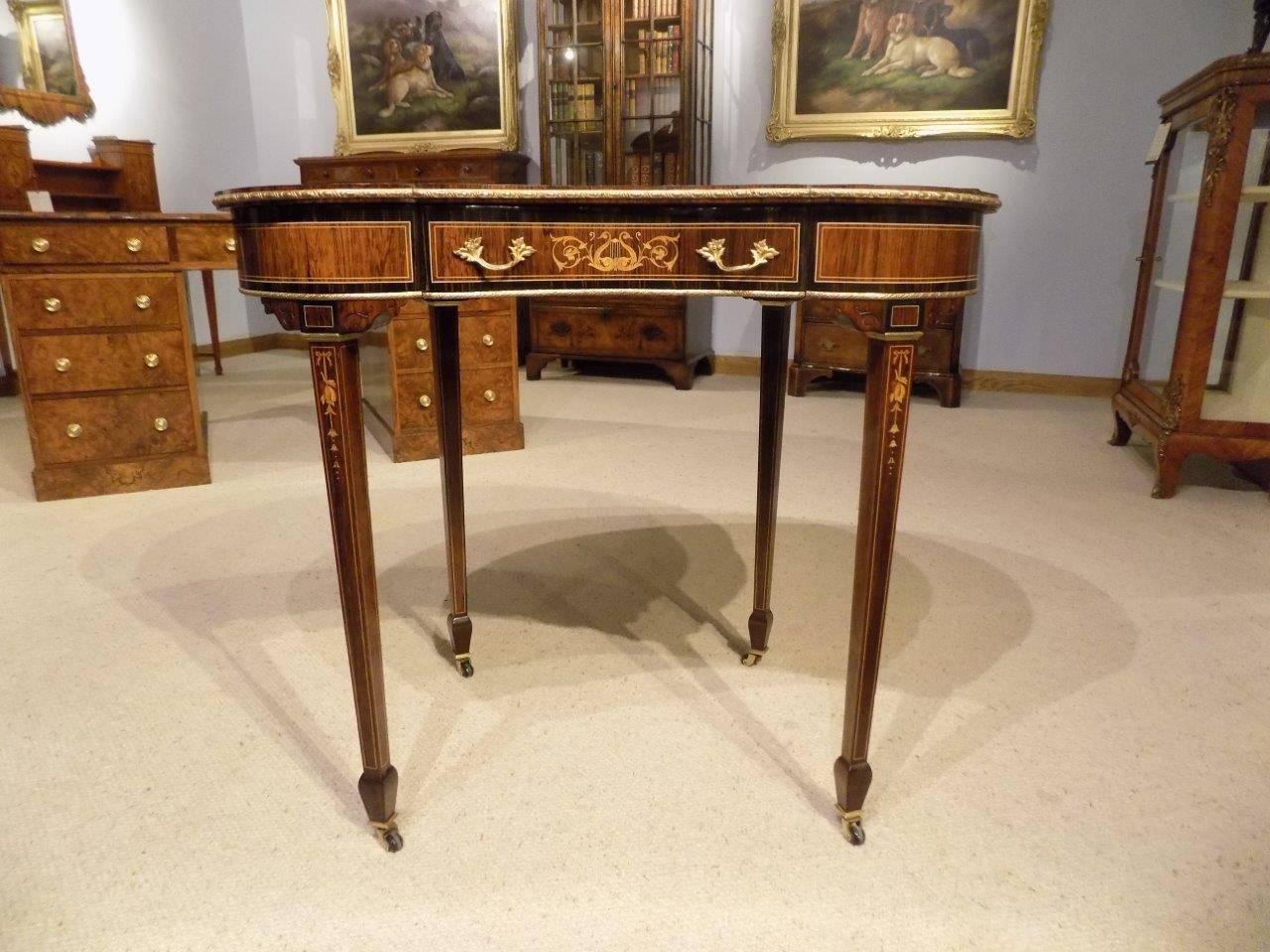 A fine quality Coromandel and marquetry inlaid Victorian period kidney shaped writing table. The kidney shaped top having a fine quality velum green leather writing surface with gilt and blind tooled detail, rosewood and Coromandel banding and