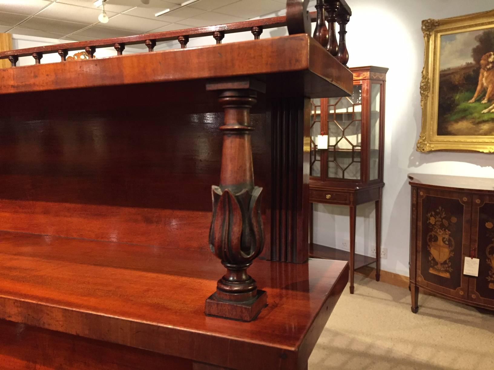 A superb mahogany Regency period chiffonier by Gillows of Lancaster. Having an upper section with two mahogany shelves with a finely turned balustrade gallery supported on finely carved columns. The lower section of breakfront outline in the finest