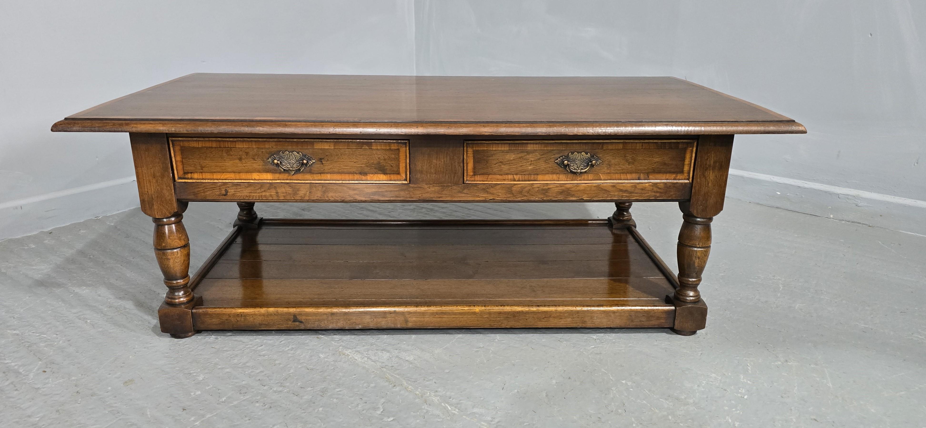 An excellent quality oak plank coffee table with two drawers, brass handles, and cross banded top and drawers, and plank undertier, in excellent condition.

18