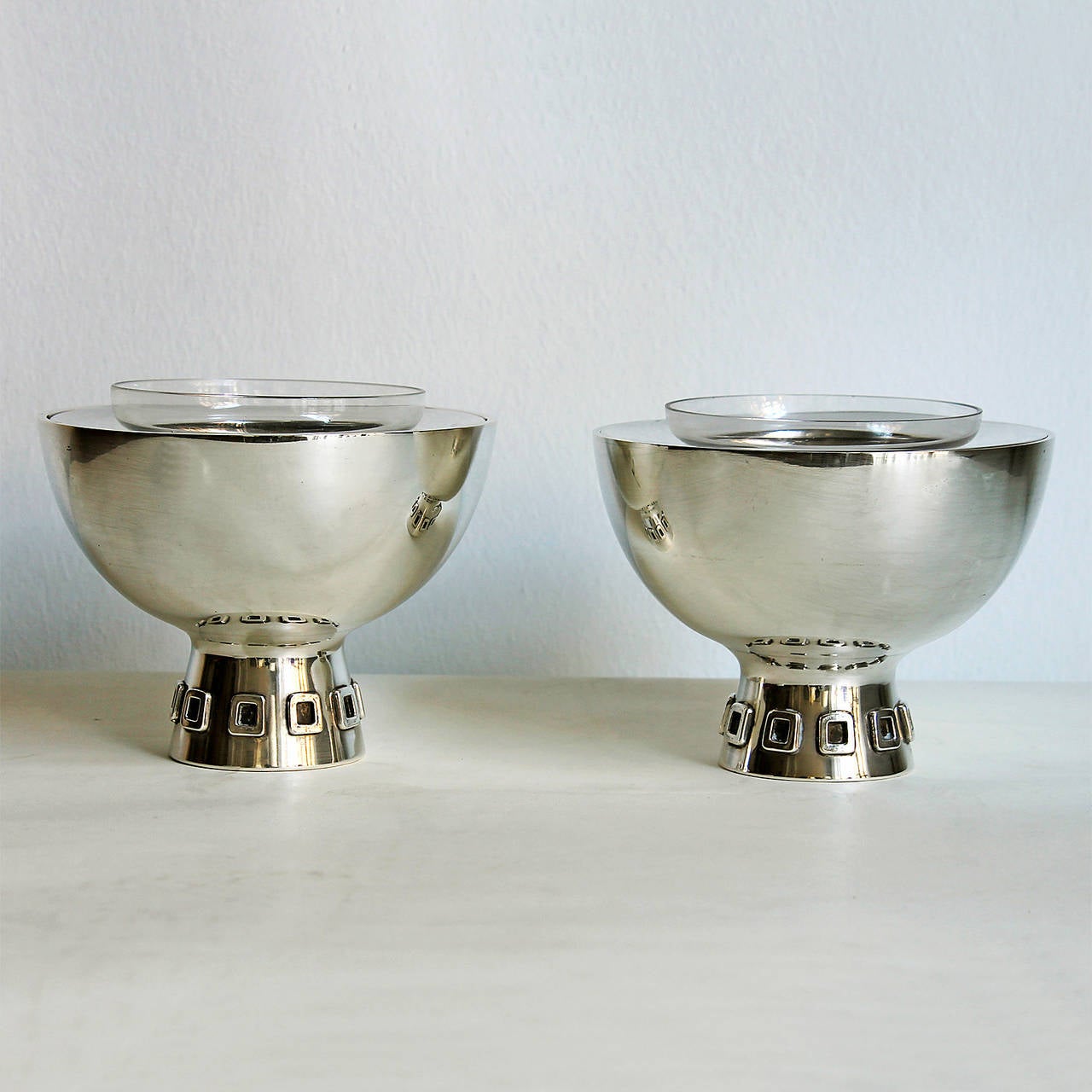 Pair of caviar bowls, sterling silver with glass little bowls, square decoration on base.
Stamp: Star (Sterling silver in Spain since 1934)
Weight: 287 grms (without glass) each
Design: Puig Doria
Spain, Barcelona, circa 1960.