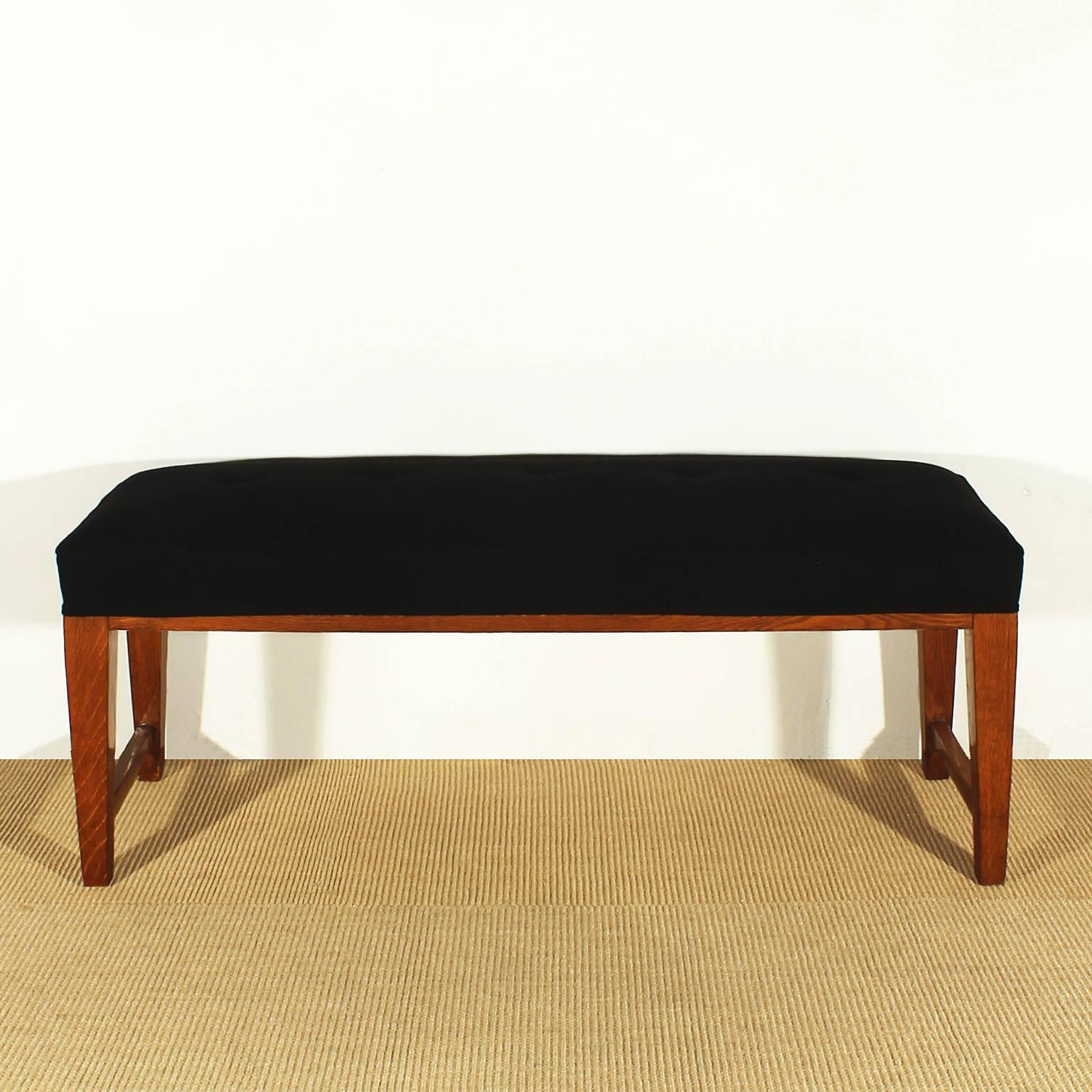 Bench made of solid oak wood, french polish, new black wool upholstery with buttons and piping strips.
France c. 1940