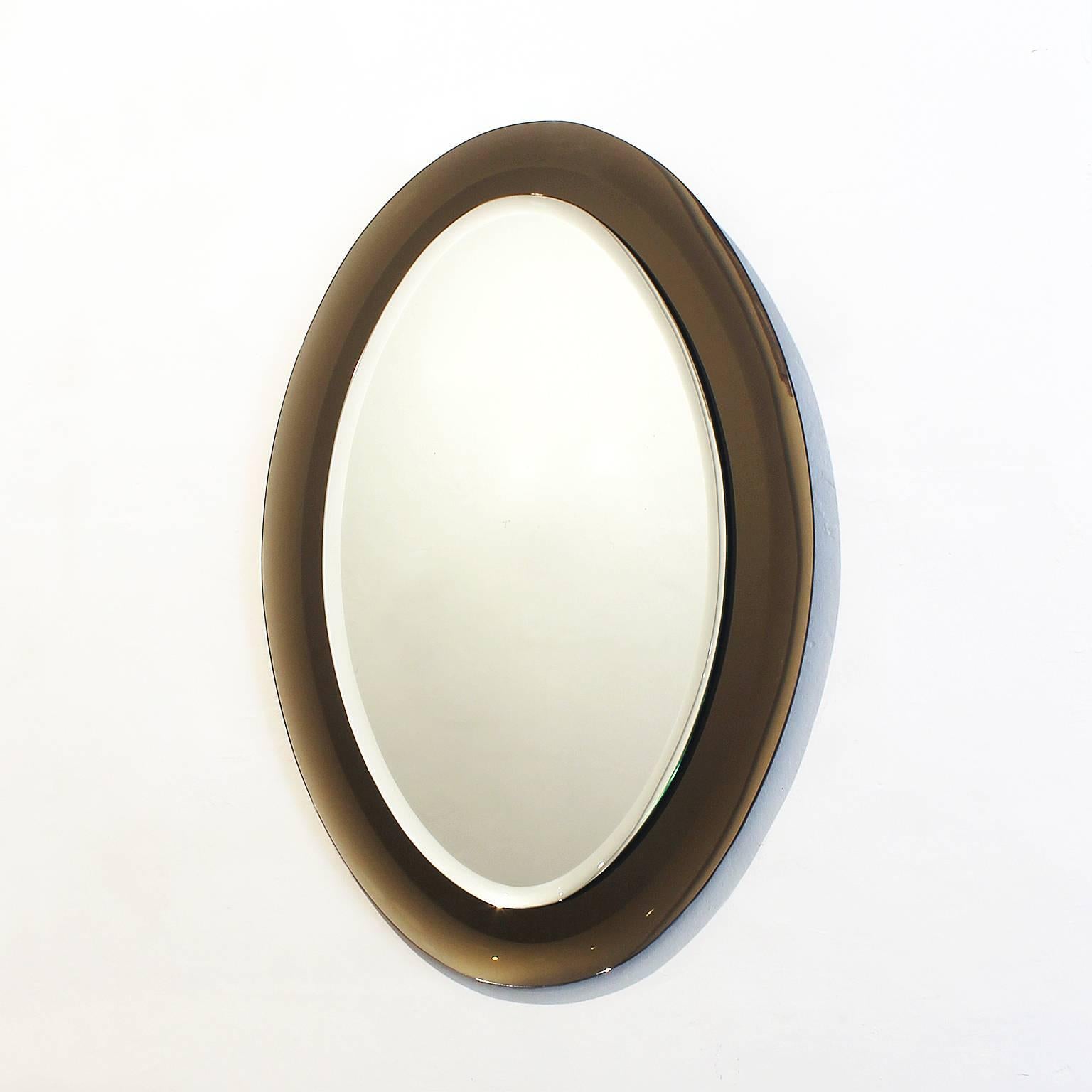 Splendid back beveled oval mirror, with back beveled smoked gray mirror frame,
Italy, circa 1960.