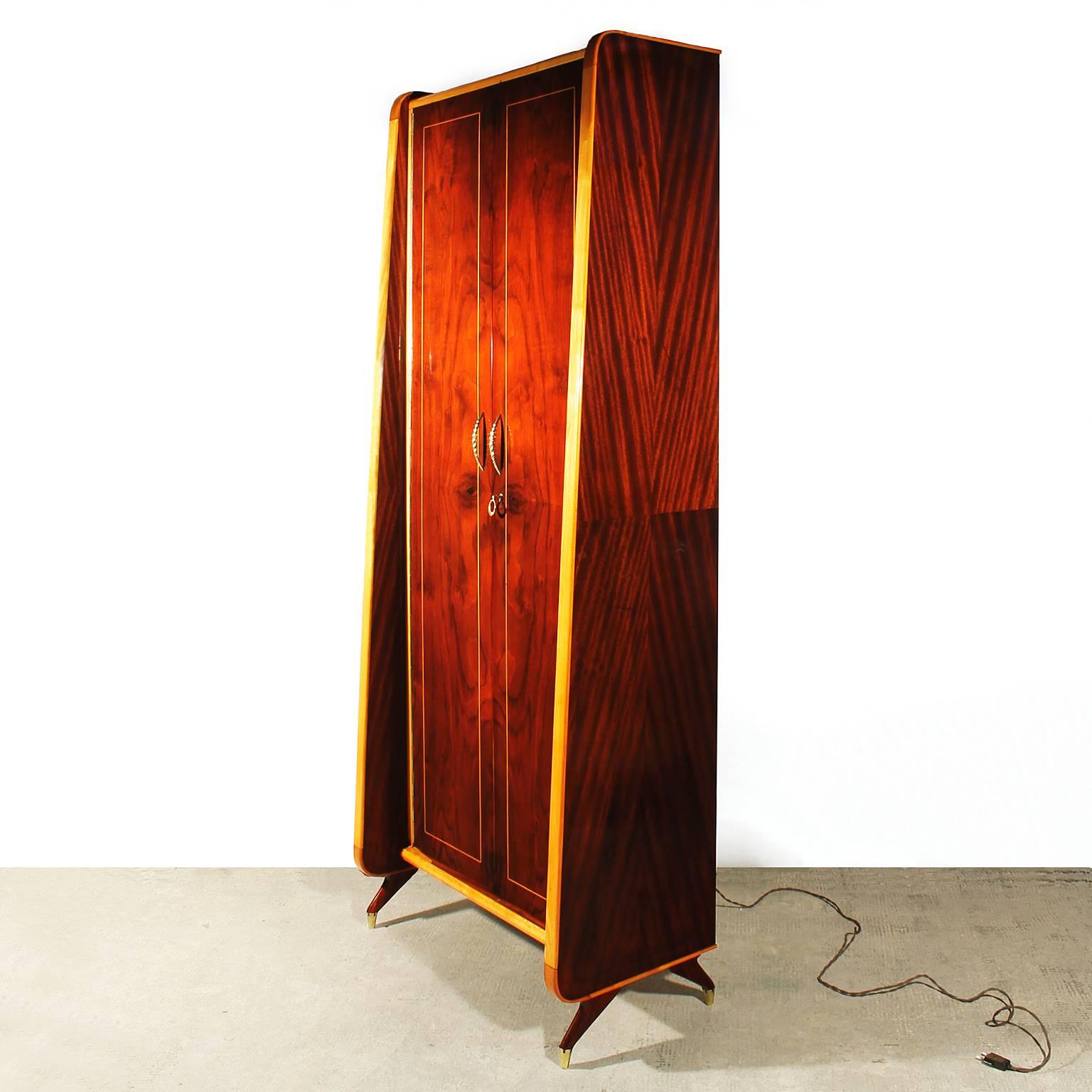 Charming entrance hall wardrobe, mahogany and rosewood veneers, maple jambs and filets, mahogany veneer inside, French polish, brass and multicolored plastic, light inside, polished brass handles, key and feet,
Italy, circa 1950.