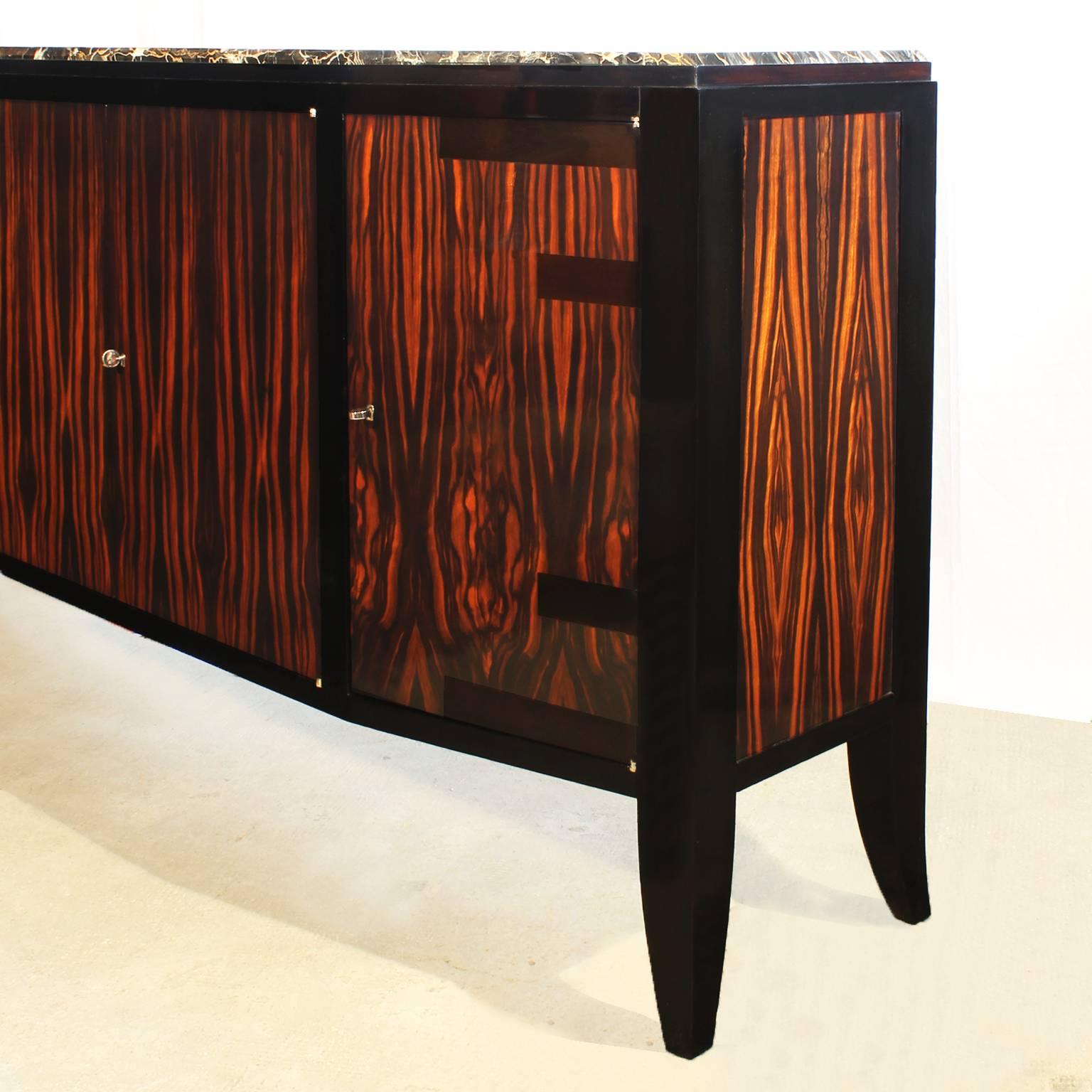 Spectacular Art Deco sideboard with four doors, solid oak structure with Macassar ebony veneer, solid stained mahogany feet and frame, French polish, Portor marble on top,
France, circa 1925.

Available the matching dining table.