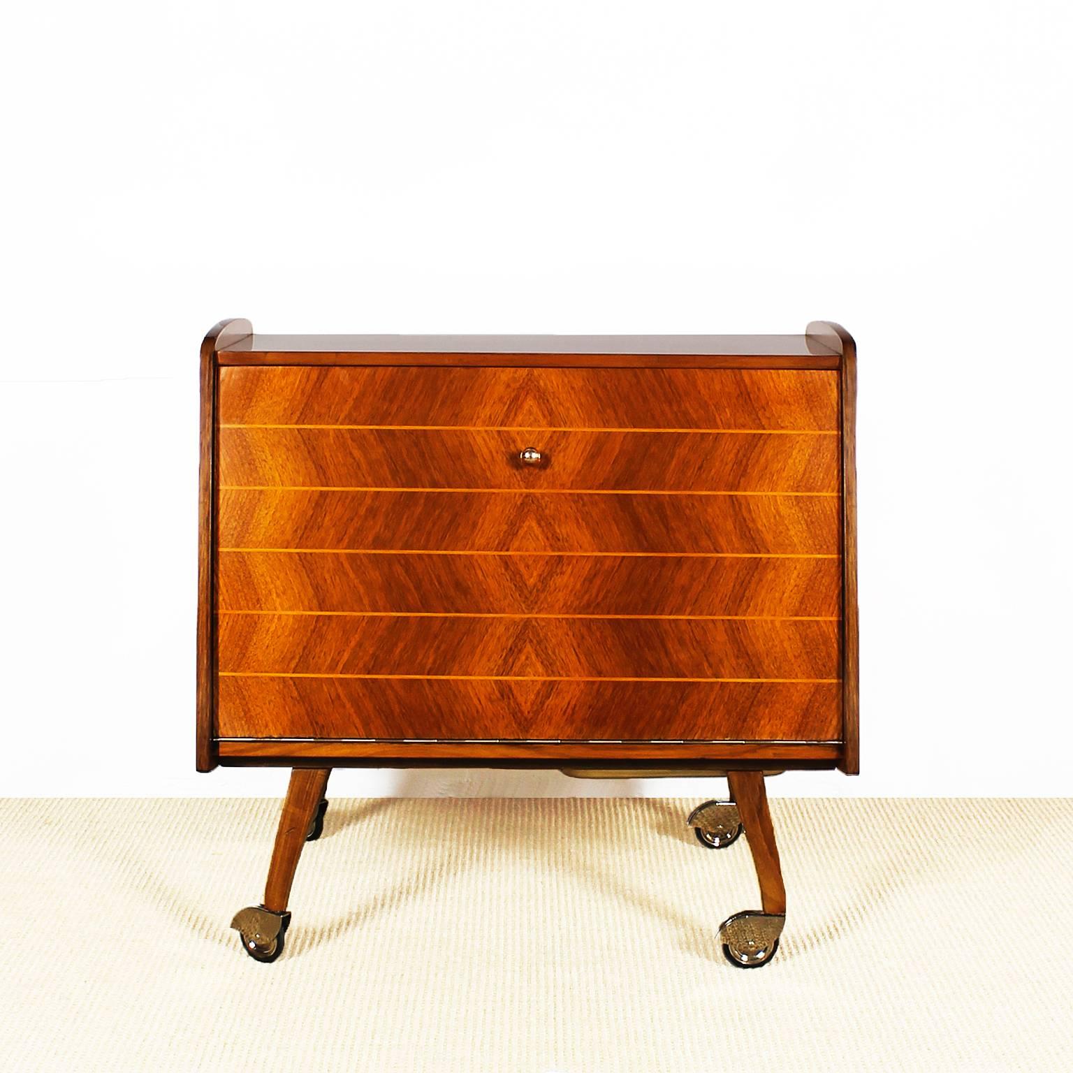 Small dry Bart or bar cart, walnut veneer and marquetry with lemon tree wood, sycamore inside, French polish, nickel-plated brass wheels and hardware,

Germany, circa 1960.