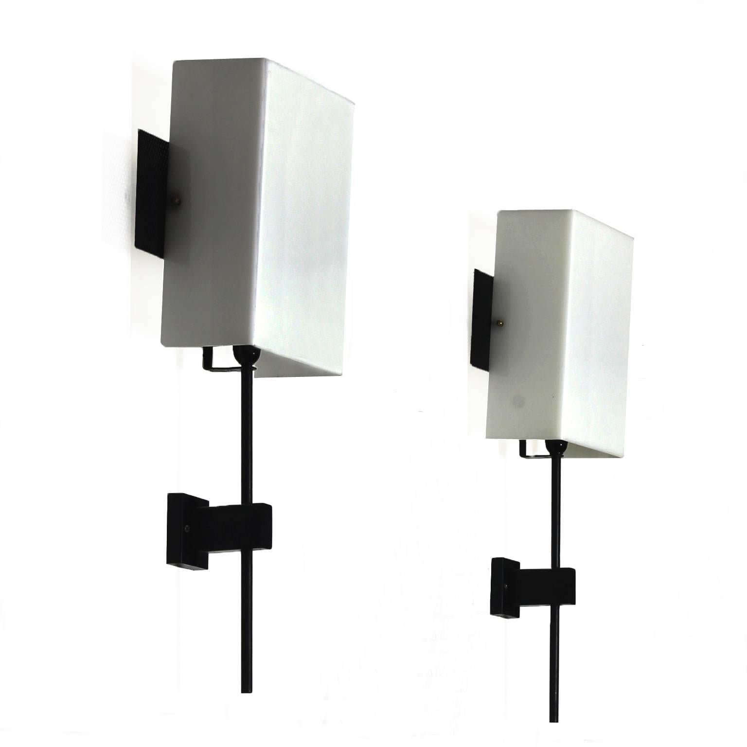 Pair of wall lights, black lacquered sheet metal and steel, plexiglass lampshades, brass screws.

Maker: GMCE.

Italy, circa 1960.