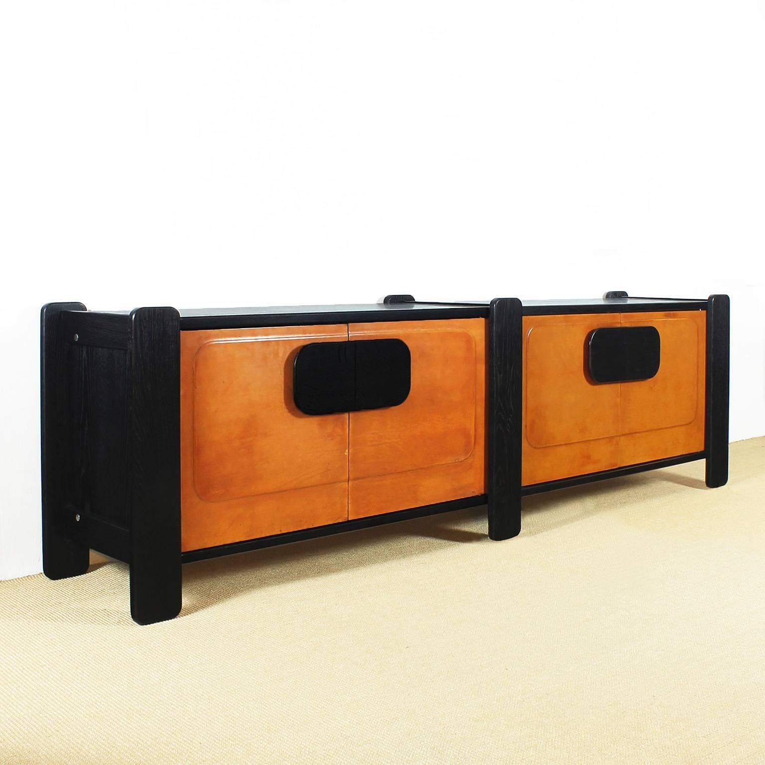 Big sideboard, black stained oakwood, satiny French polish, four doors covered with sheepskin,

France, circa 1970.