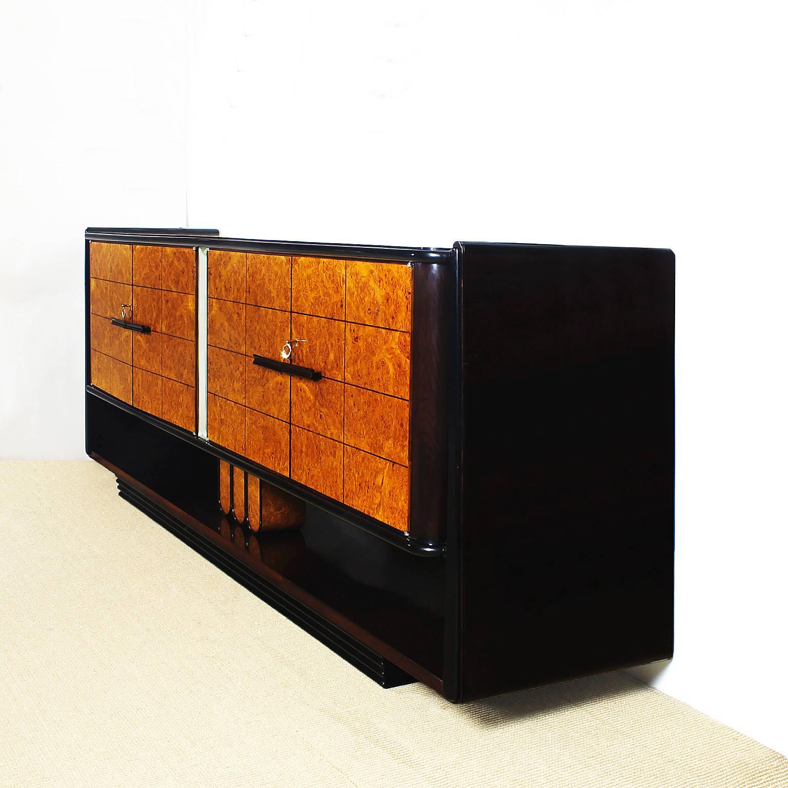 Important Art Deco sideboard with four doors, elm and rosewood veneer and black lacquer, French polish, blond mahogany and rosewood inside, solid rosewood handles, beveled mirror decoration between the doors, nickel plated brass keys.

Attributed