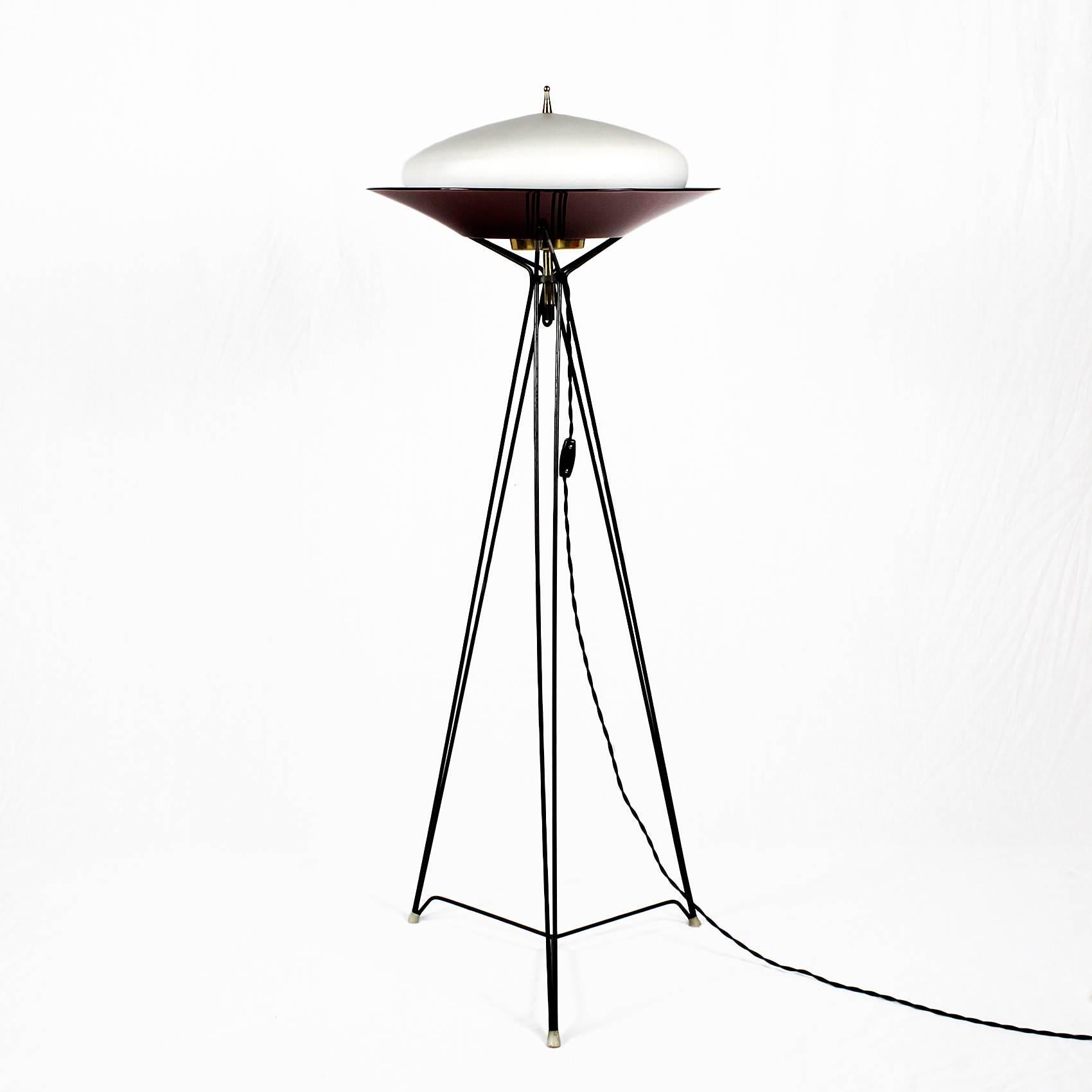 Tripod standing lamp, black lacquered metal, polished brass lightning system, white opaline and red translucent plexiglass.

Italy, circa 1960.