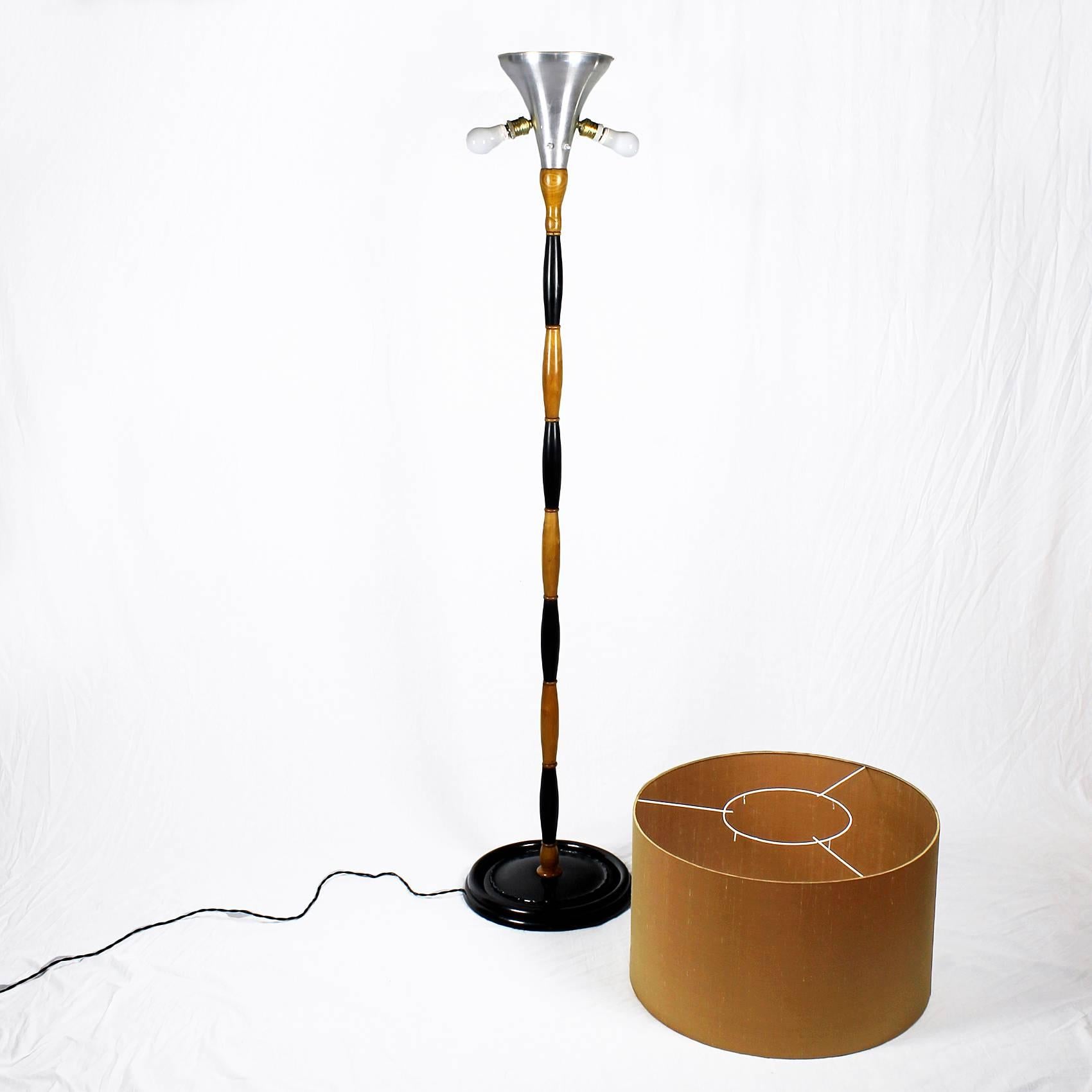 Standing lamp, two-colored stand, ebony stained beech and sycamore, french polish, golden silk lampshade.

Italy, circa 1940.