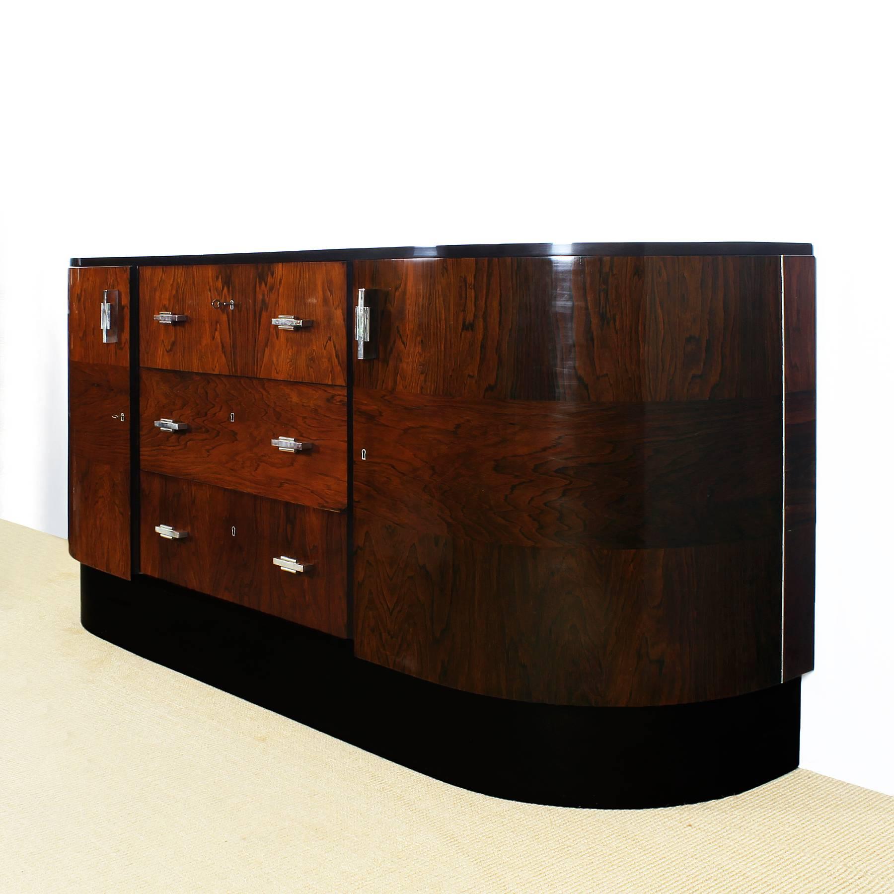 Art Deco curved sideboard, solid mahogany and Rio rosewood veneer, French polish, two-doors with shelves inside and three drawers, stained mahogany base, nickel-plated brass handles and hardware.
Maker: Casa Reig
Spain, Barcelona