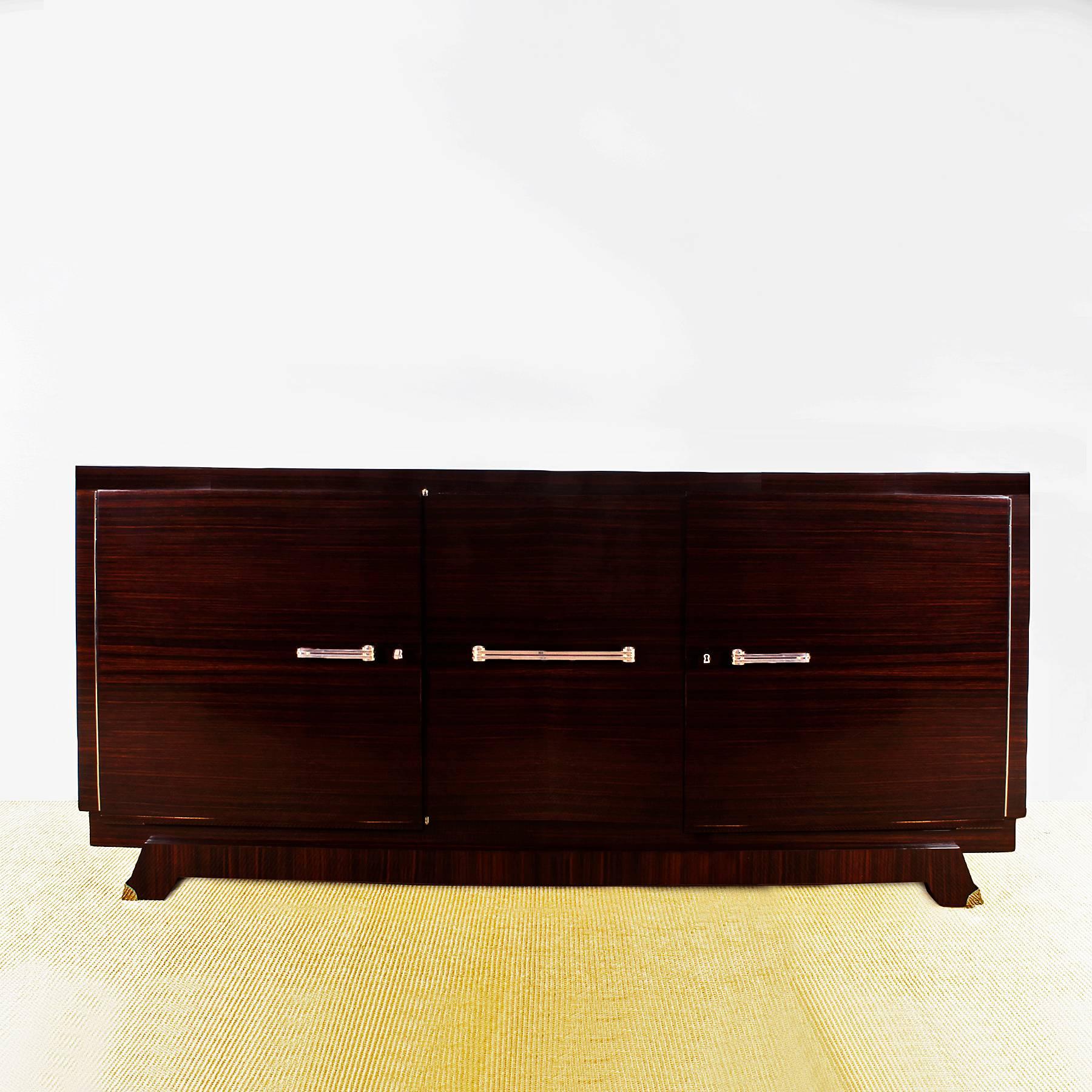 Art Deco sideboard with three doors, solid mahogany structure, interior, shelves and drawers, French polish. Nickel-plated bronze hardware, handles and base.
France, circa 1930.