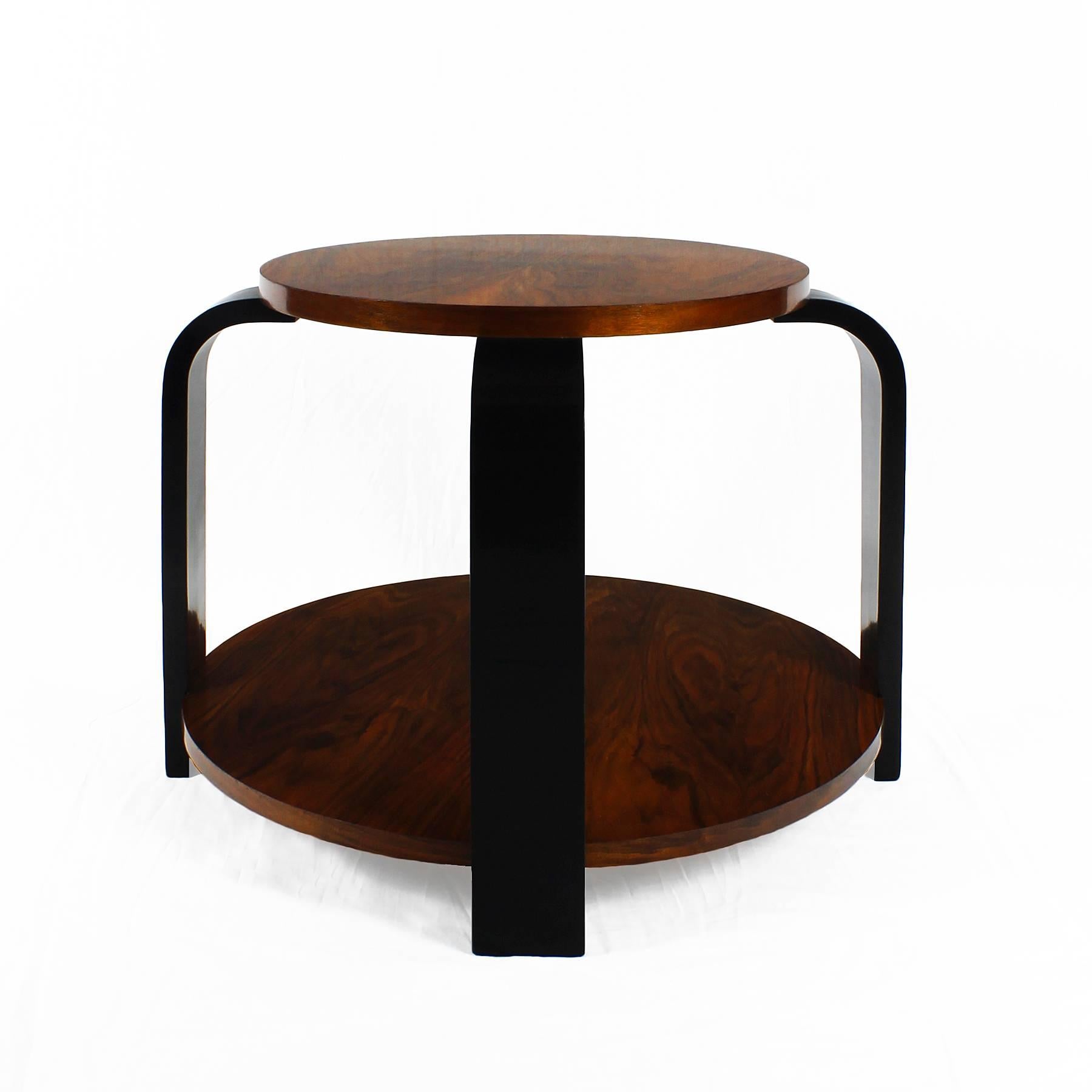 Art deco side table with four curved ebonized beech stands and two walnut veneer trays, French polish.

France, circa 1930

Diameter of the top: 55 cm.