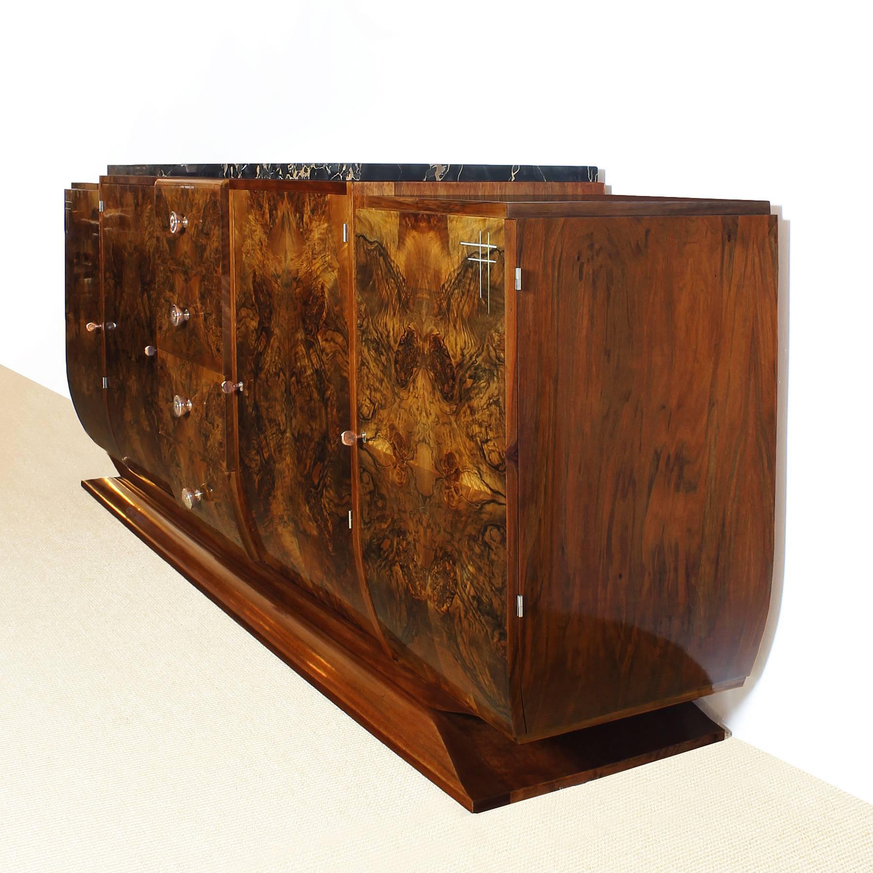 Spectacular rounded Art Deco sideboard, solid oak structure with burr walnut veneer, French polish. Central block with four drawers, on each side one door with two shelves and one with aluminium encrustation decoration and three shelves. Solid