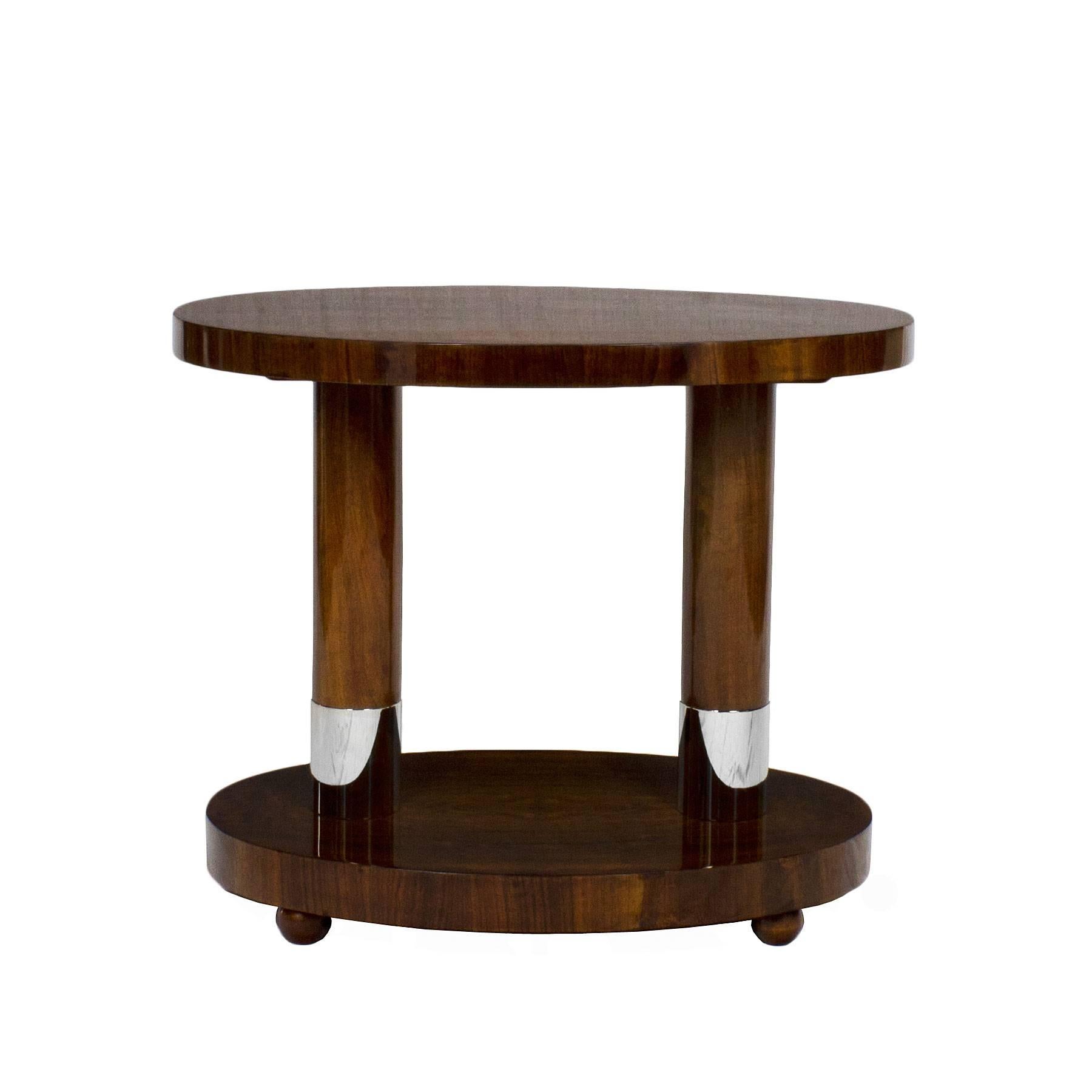 Splendid oval sidetable with 4 rounded feet, 2 solid walnut stands with nickel plated brass bases. Really nice walnut veneer on top.

France c. 1940