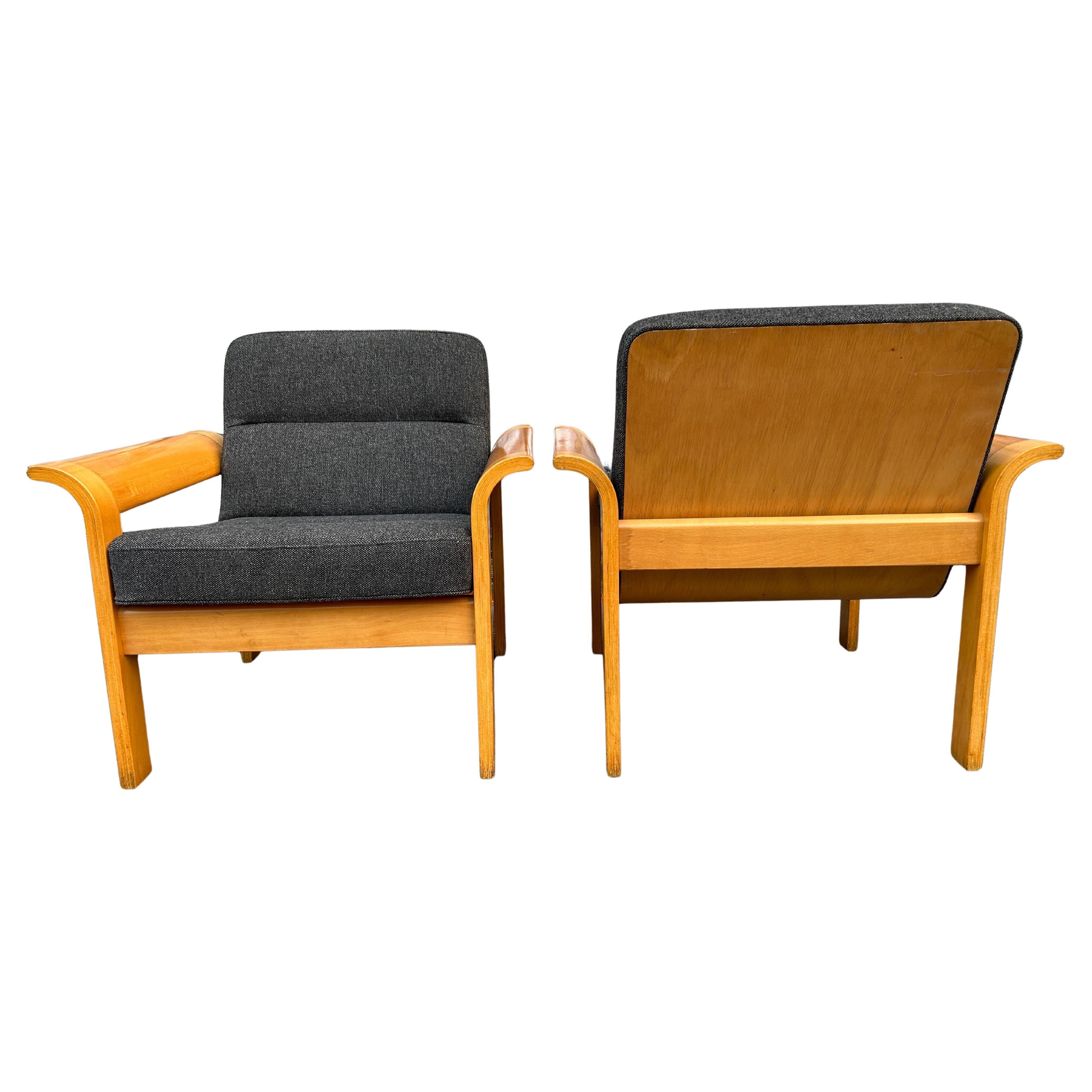 A nice pair of Danish mid-century lounge chairs blonde bentwood arms designed by Rud Thygesen for Magnus Olesen / Botium. marked with labels underneath Danish control. Featuring beechwood frames with flared wood armrests and gray wool upholstery. c.