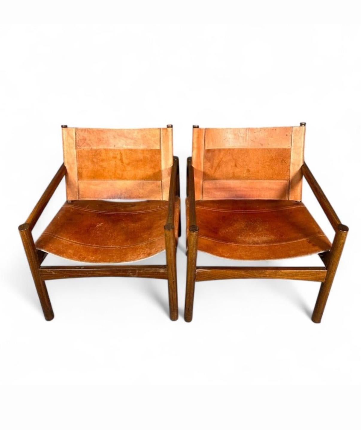 Paire de chaises longues en cuir Peg-Lev et bois brésilien Safari Sling de Michel Arnoult, du milieu du siècle dernier. Chaises modernes brésiliennes en bois dur de jacaranda avec supports en cuir et accoudoirs plats, tabliers en forme et sièges et