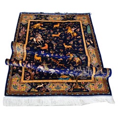 Fina alfombra persa de seda que representa una cacería real en azul noche-en stock