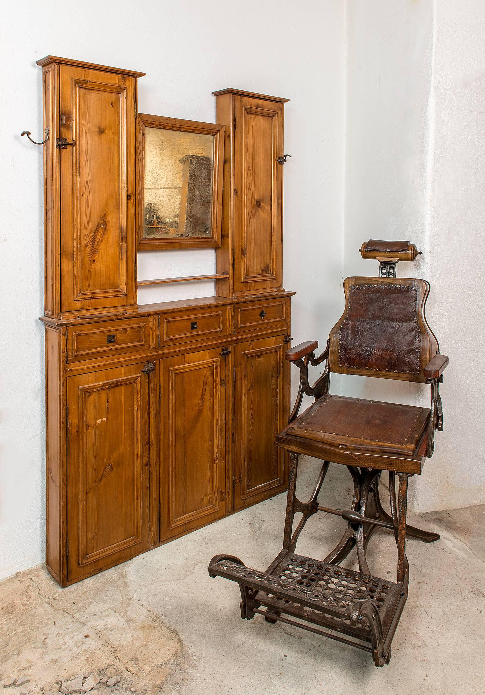 Early 20th century barber shop cabinet in wood, with mirror and storage.