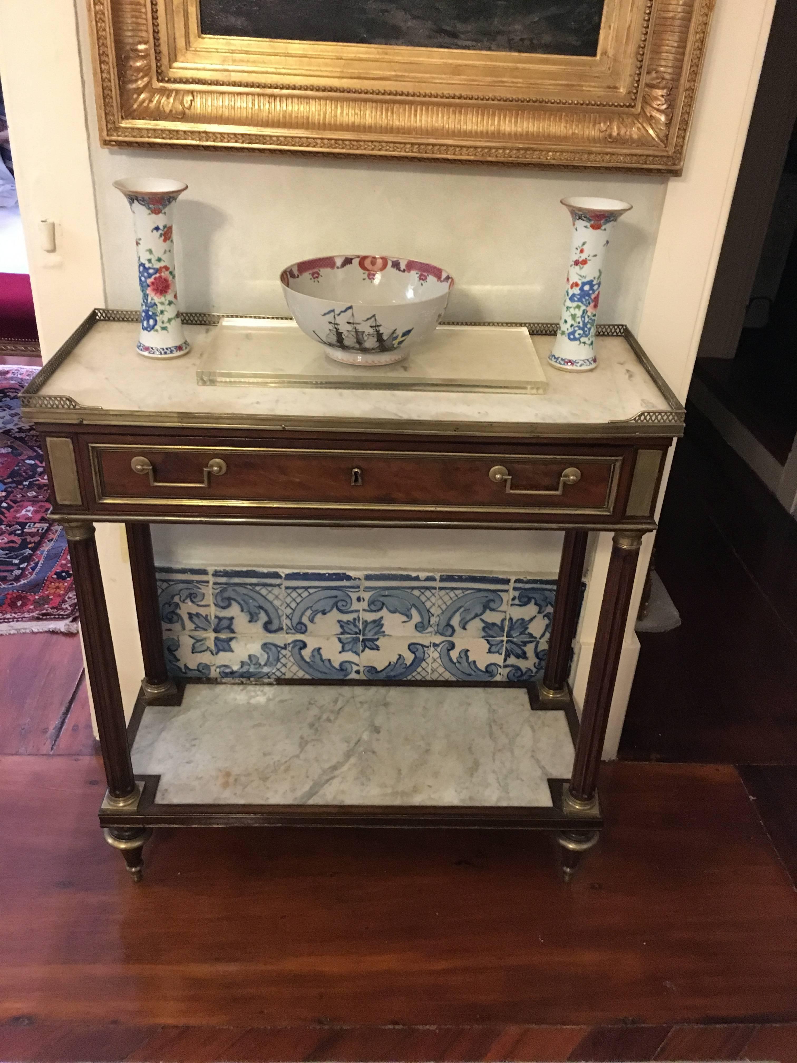 For sale on 1stdibs  an early 19th century Louis XVI mahogany marble topped and bronze mounted console table. The console has a bottom shelf also with white marble top. Being a very narrow piece it could be a great console to place on a dinning room