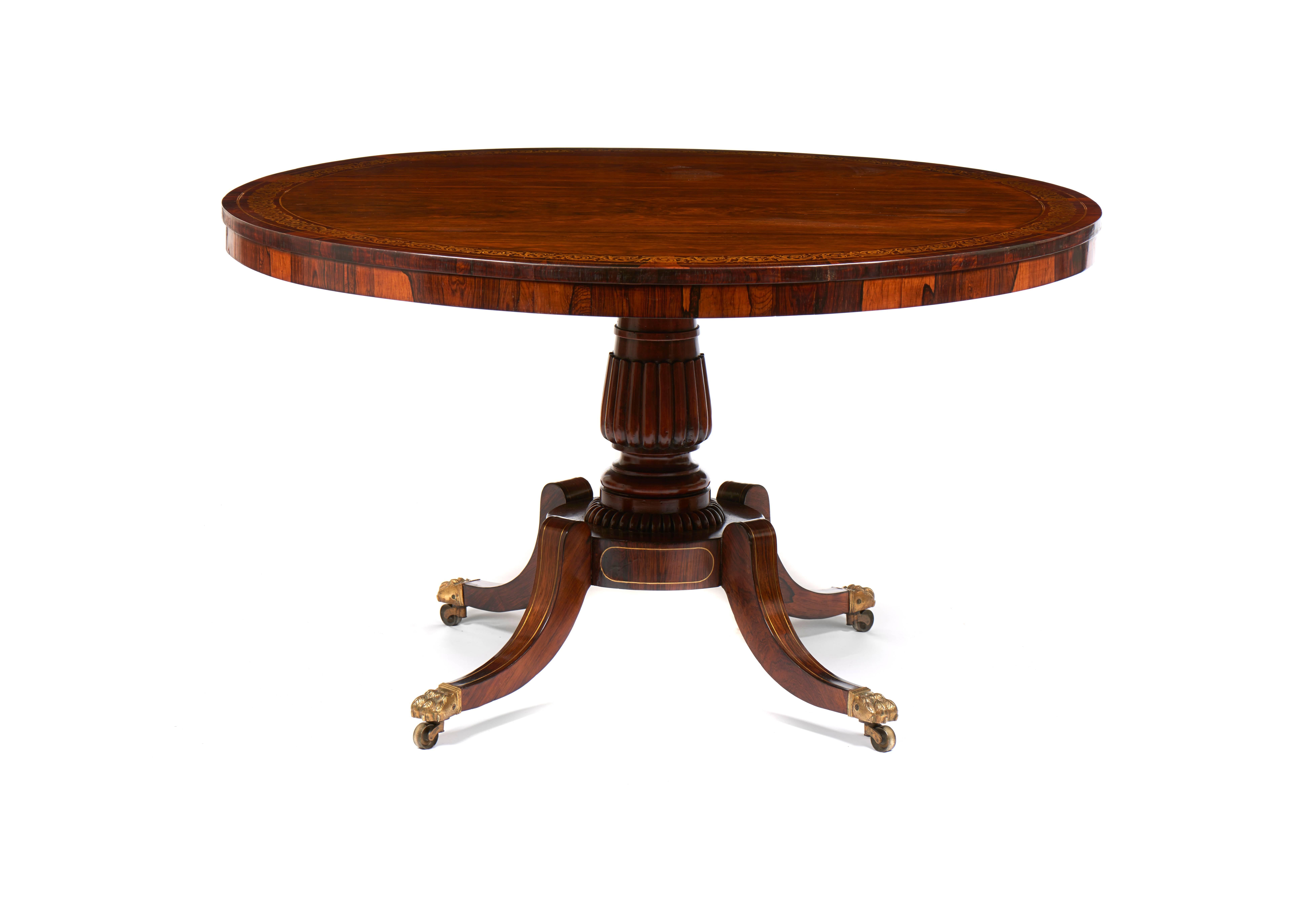 For sale on 1stdibs a Regency rosewood tilt-top breakfast table with a brass inland border on a turned reed column pedestal with four splay legs, terminating with the original brass caps and castors.