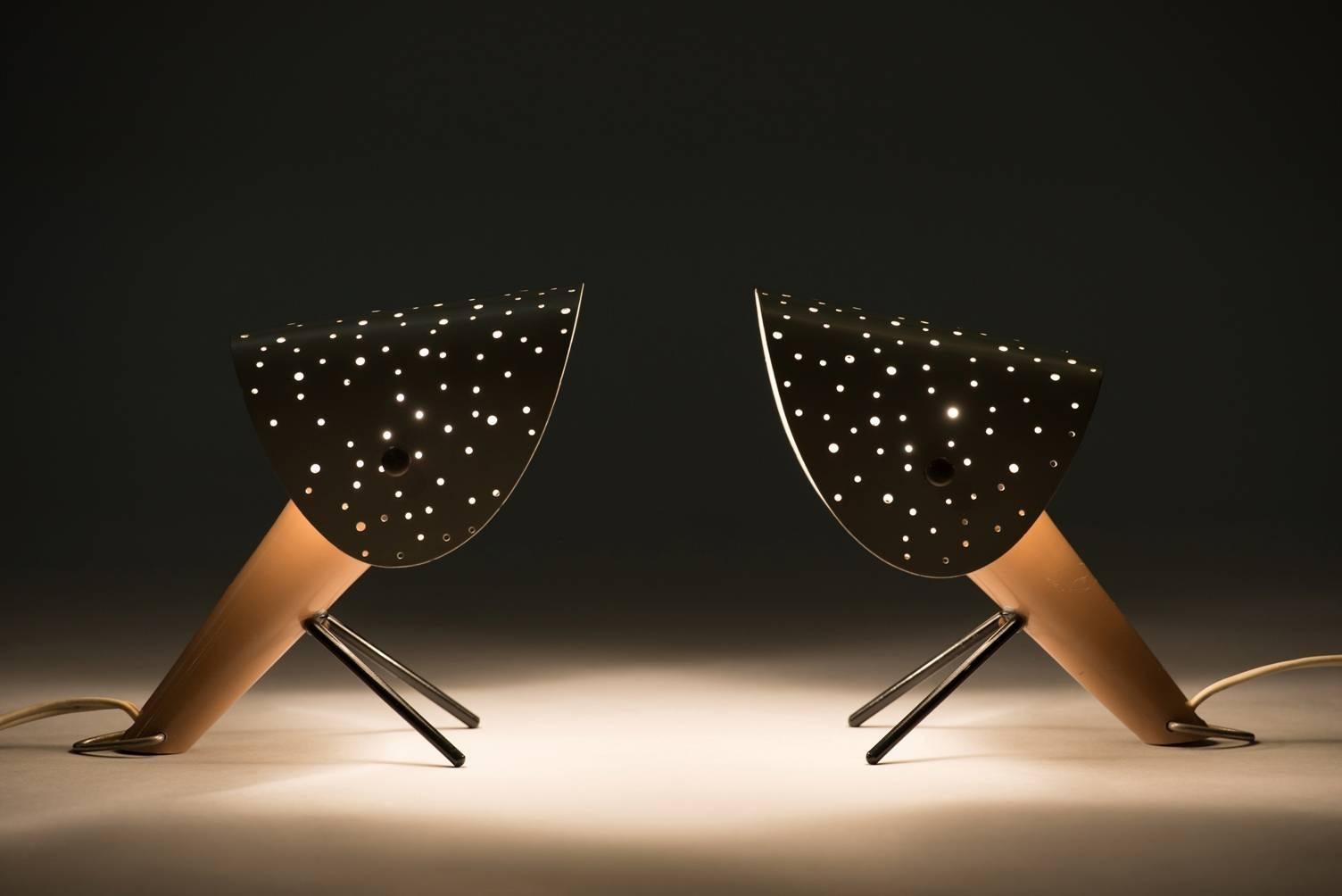 A pair of table or wall lamps. Lacquered metal body with V-shaped lacquered metal legs and lacquered metal shades with pierced holes.
Producer: Egon Hillebrand.