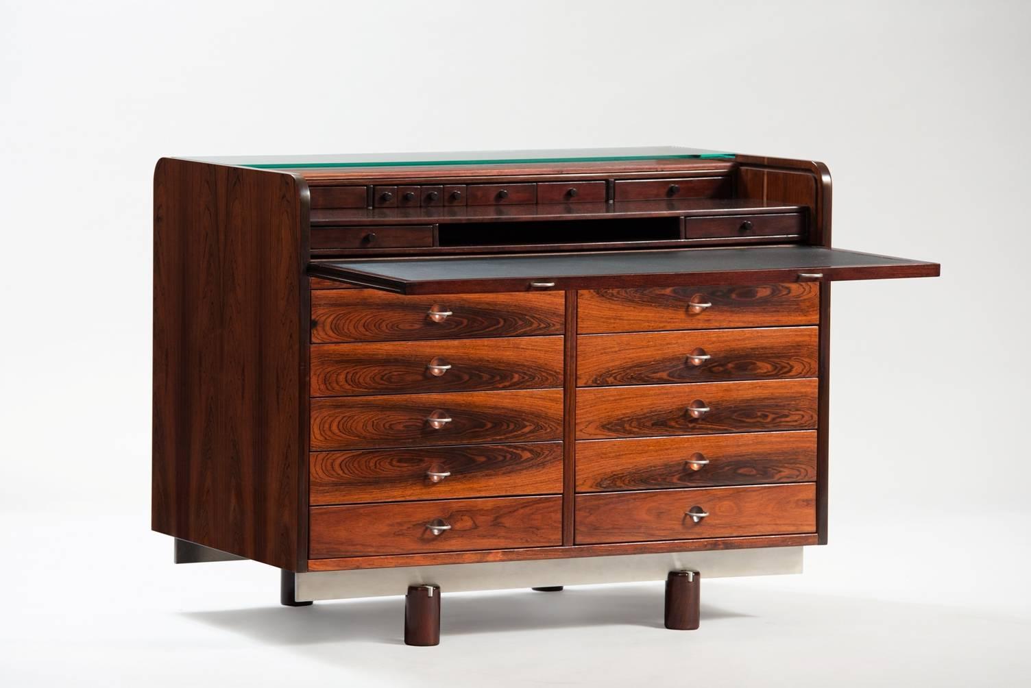 Rosewood writing desk 804 model, this roll top design opens by pulling out the leather writing surface. The glass shelf remains in place to hold items while roll top is moving.
Inside conceals eight drawers and ten outside drawers with half circle