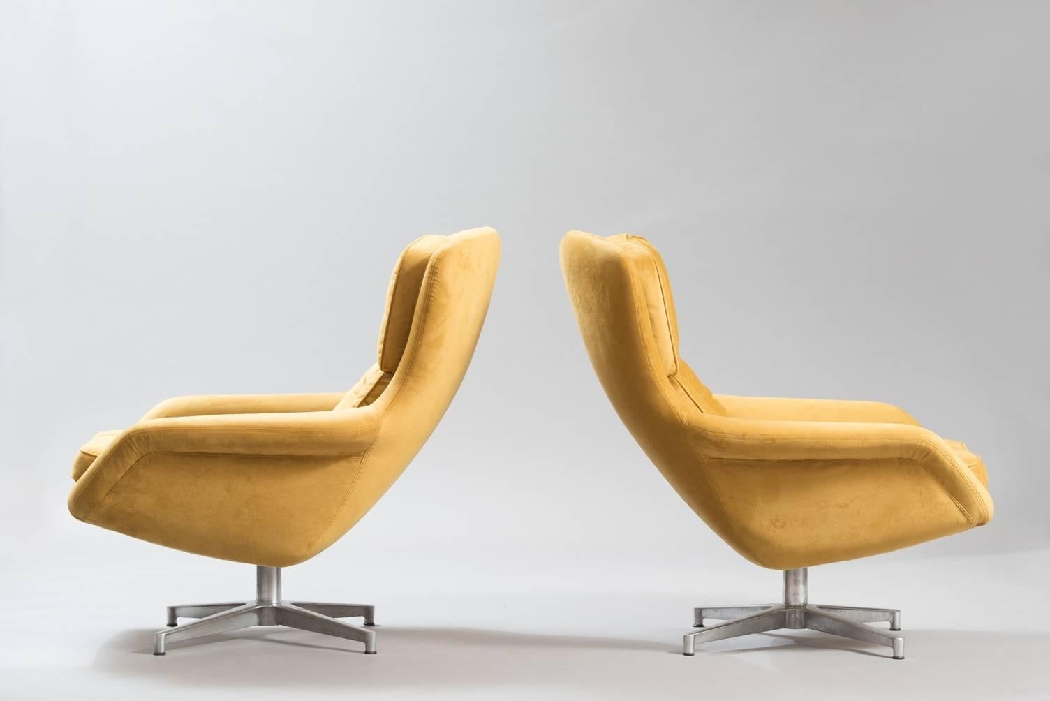 A pair of swivel chairs, re-upholstered in yellow mustard velvet, aluminium base.
Producer: DUX.