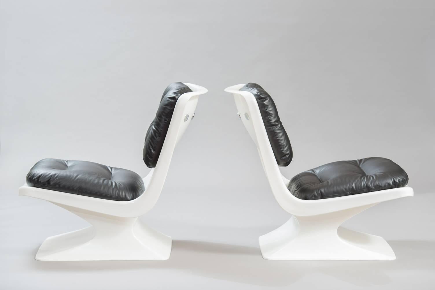 A pair of white plastic chairs, re-upholstered in black leather.
Producer: Grosfillex.