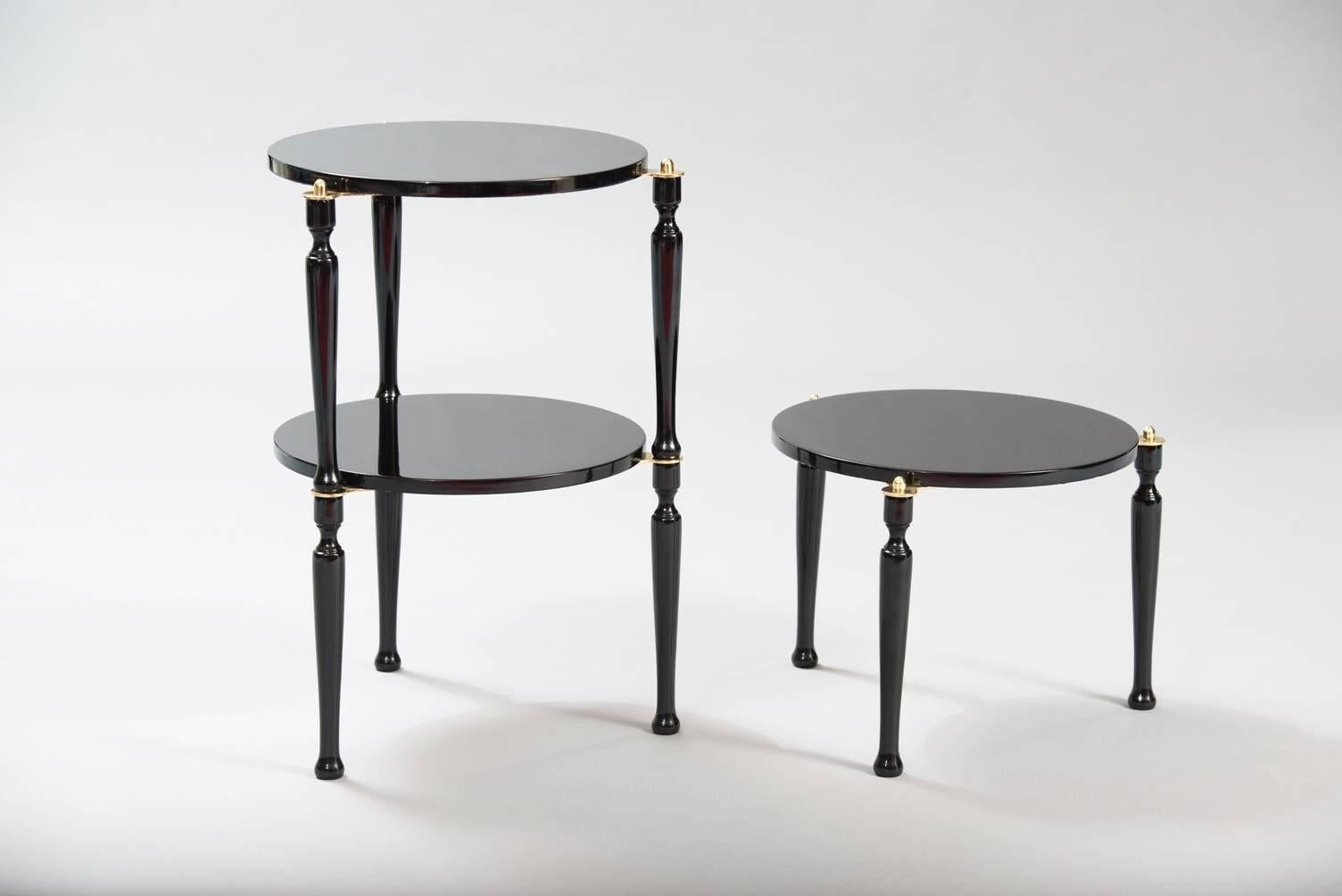 Set of three stackable black lacquered wood and brass side tables.