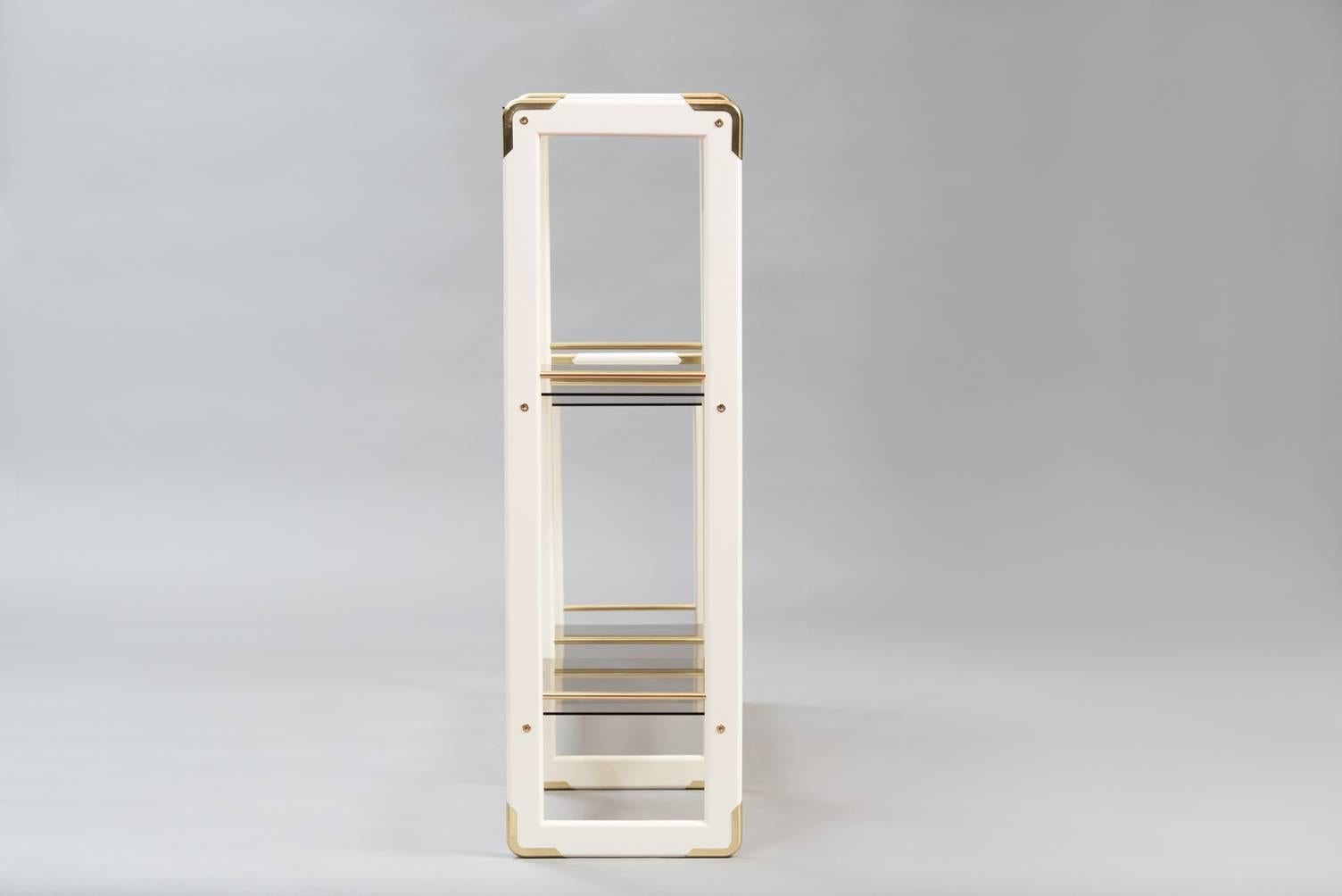 Two heights bookshelf, in lacquered wood, brass and smoked glass.
Measures: W: 1.42 cm, D: 37 cm, H: 120/69 cm.