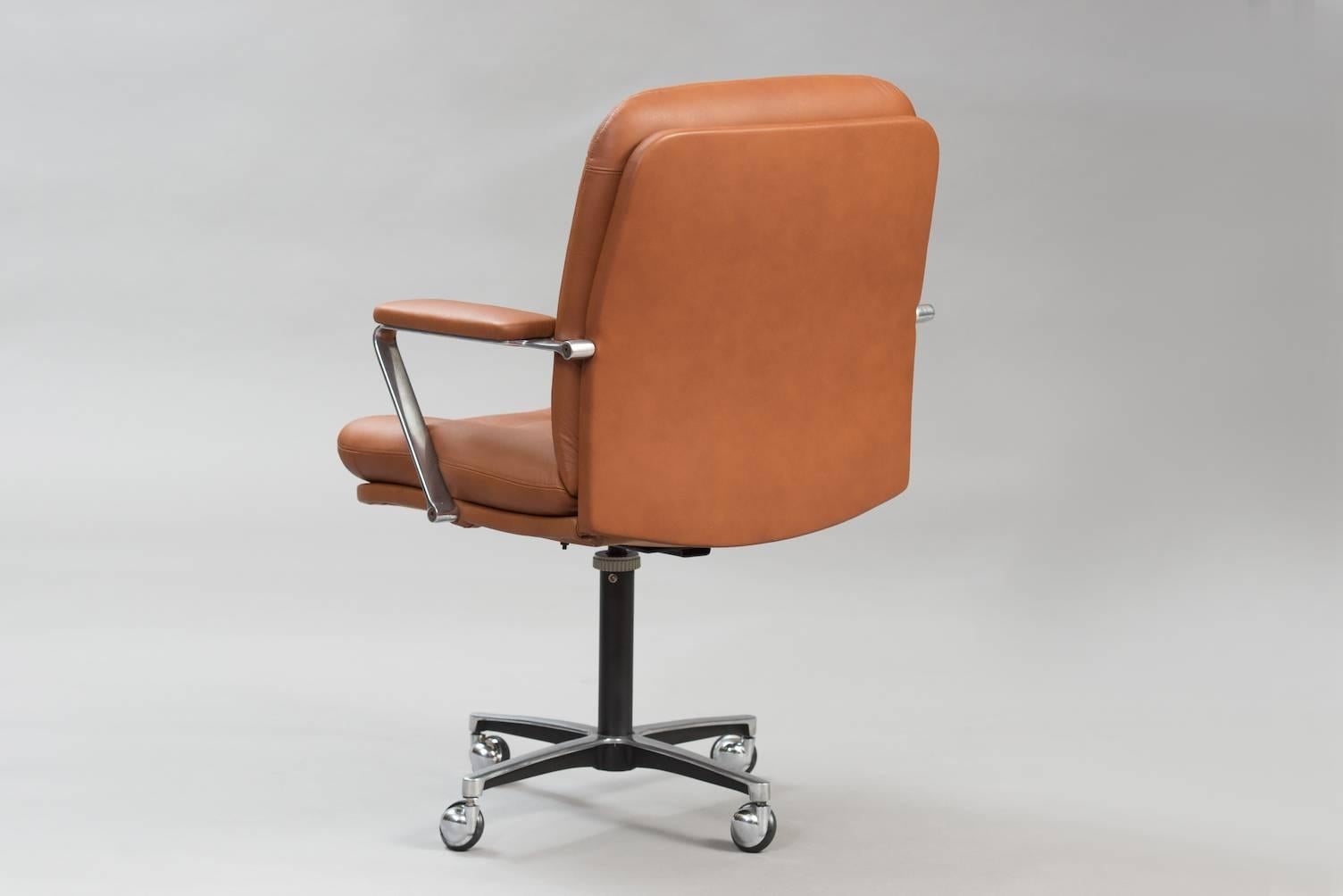 Swivel desk chair in aluminum, re-upholstered in cognac color leather.