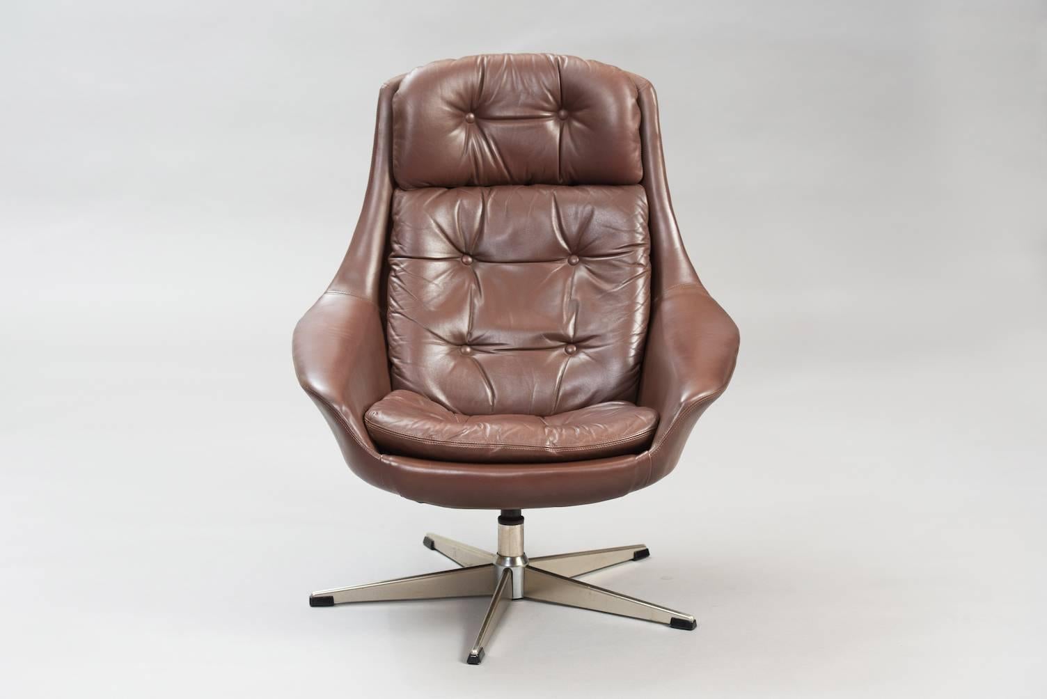 Swivel lounge chair floating on a brushed steel point base, upholstered in brown leather.
Producer: Bramin.