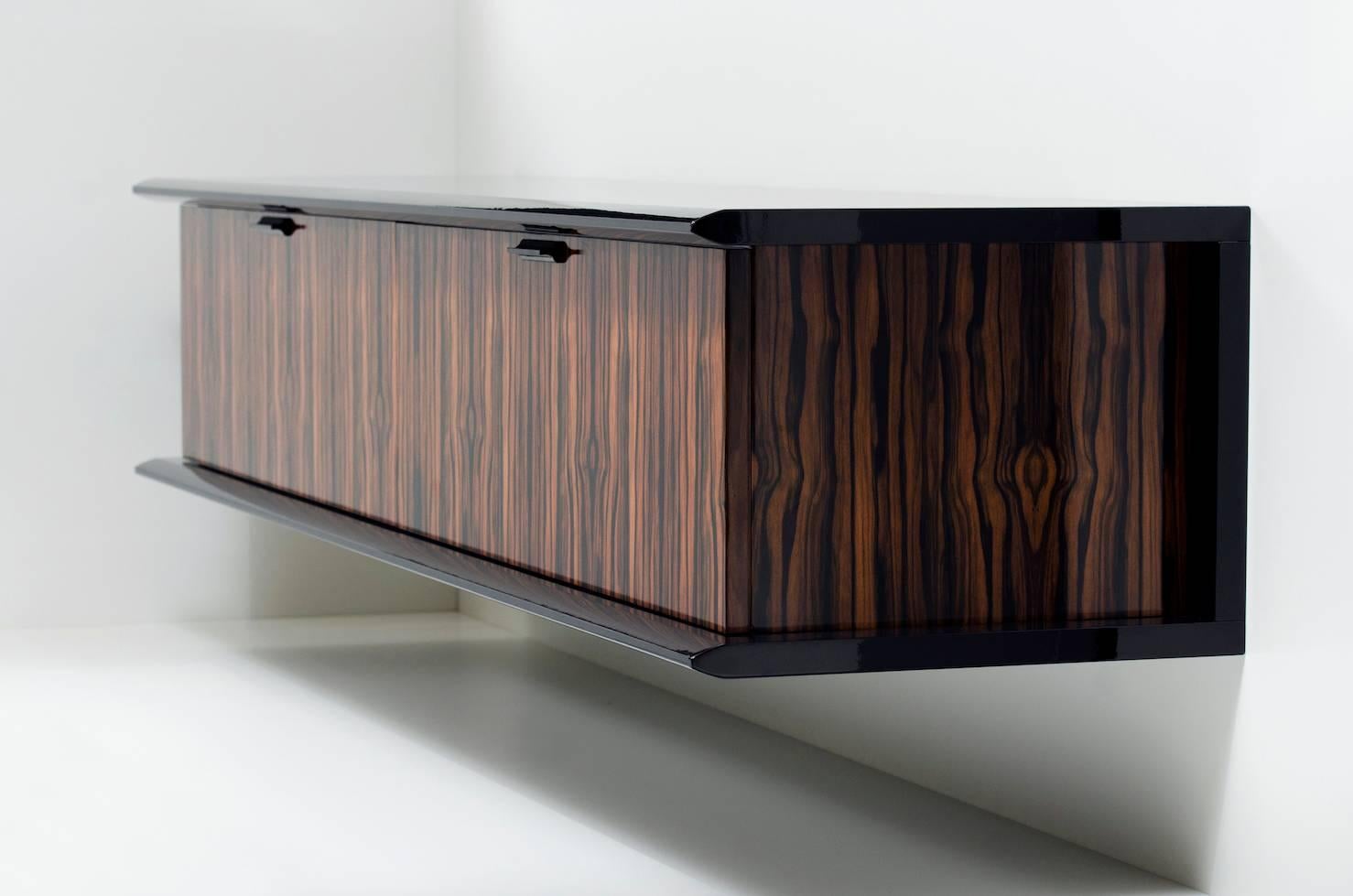 Shown in French polished Macassar ebony and black lacquer, with sycamore and black leather interior. The Model One credenza by Pipim is customizable to any dimension and is available in a variety of woods, stains and lacquers. Multiple interior