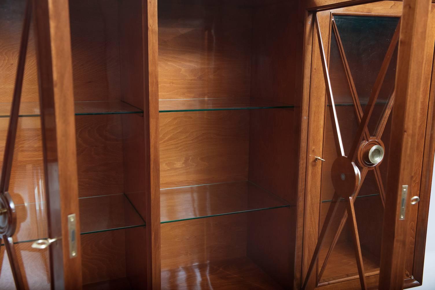 Walnut display cabinet with brass door handles.