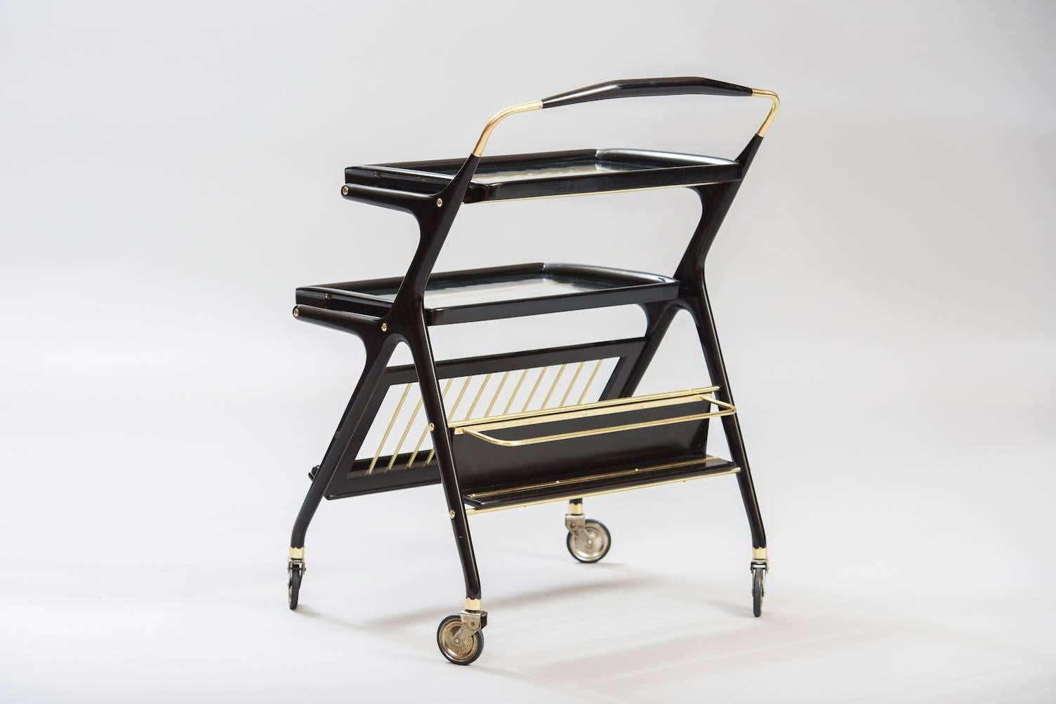 Bar cart or serving cart in ebonized wood, both upper and lower tray are removable. Bottom front rack for magazines, rear shelf for bottles.