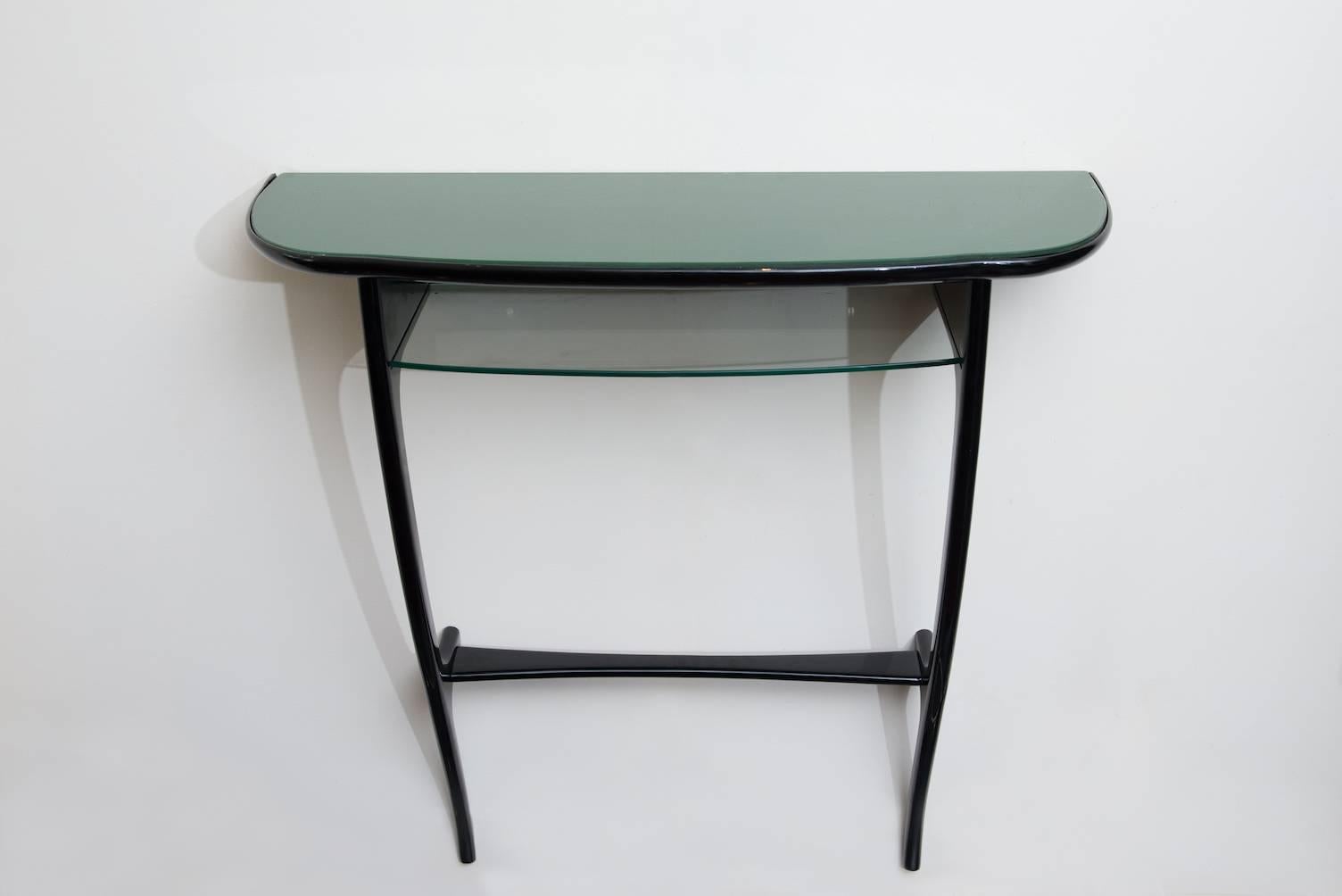 Small ebonized wood suspended console, with a glass shelf and a green lacquered glass top.