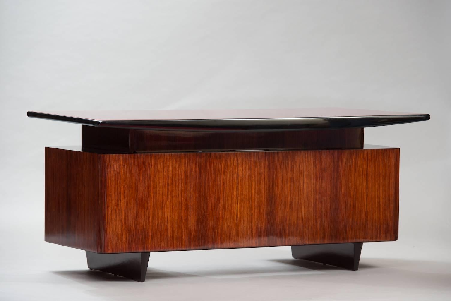 Rosewood desk with bordeaux lacquered glass top.