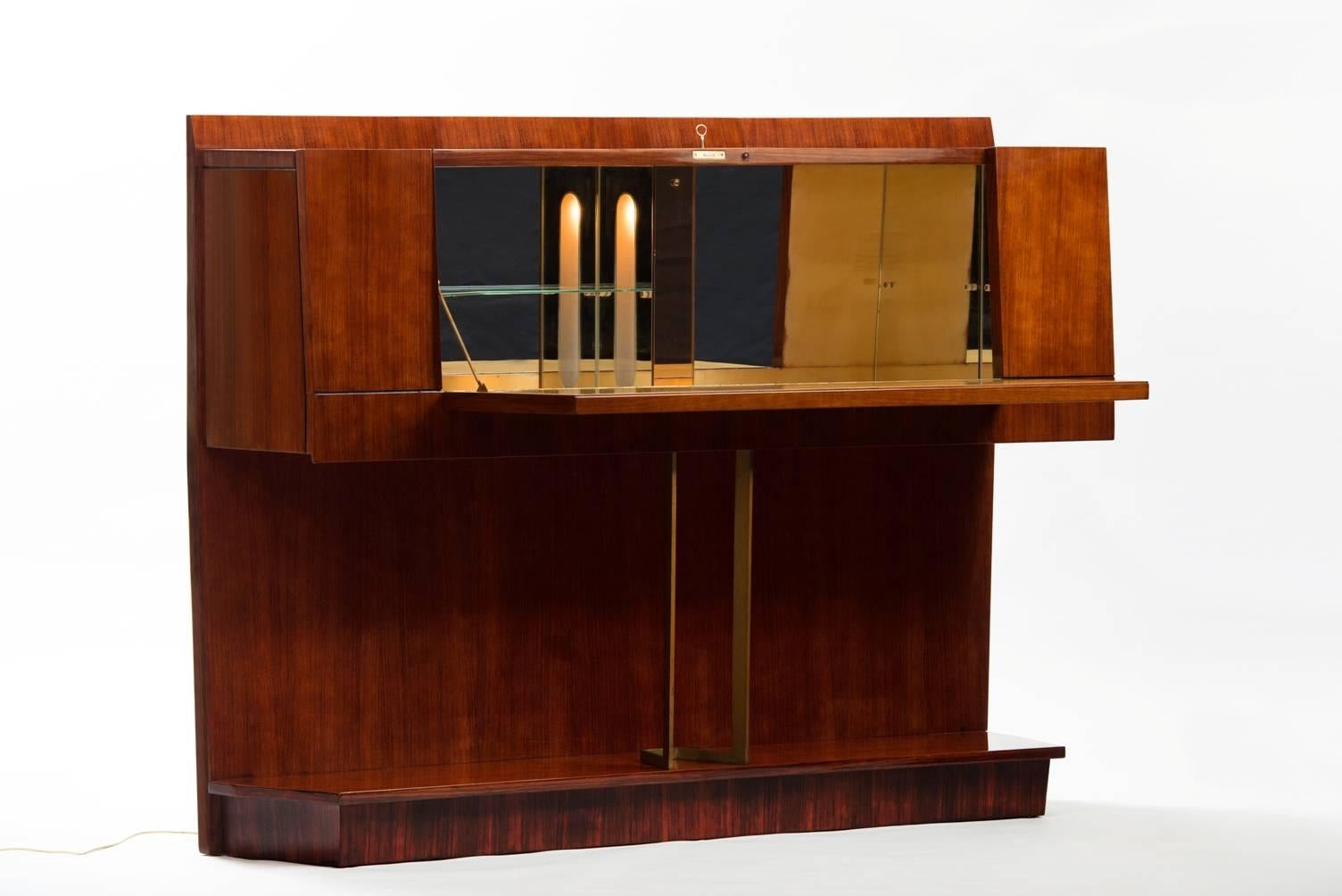 Rosewood bar cabinet with lighting inside and illustration at the door, central support in massive brass.