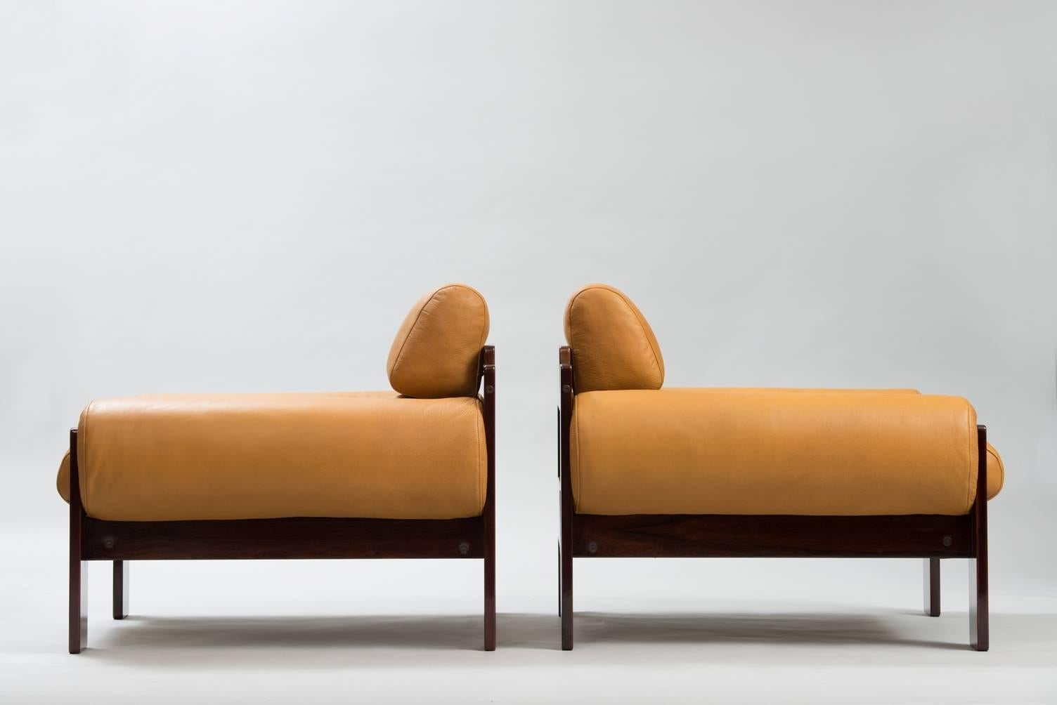A pair of rosewood armchairs re-upholstered natural waxed leather.