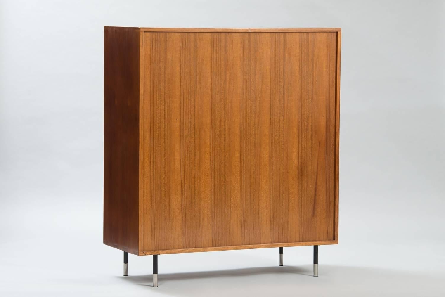 Teak display cabinet, legs and drawers handles in chromed metal and black lacquered wood.