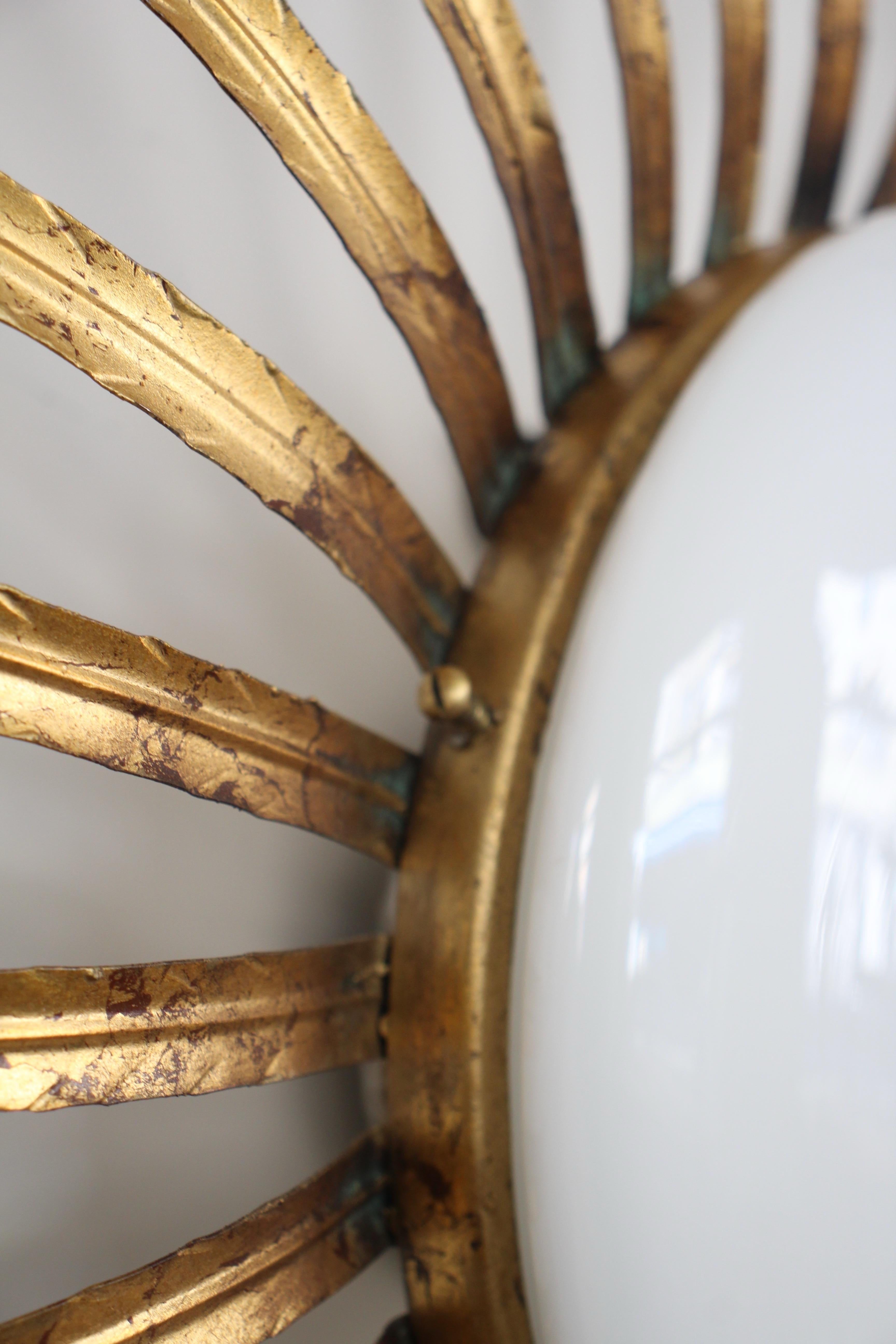 English:
Vintage sunburst wall sconce in hammered gilt metal with a white opaline glass center. French work from the 1950s. Elegant and decorative, it emits a warm and soft light.
Nice patina .

It is initially a ceiling light, you can use it as a