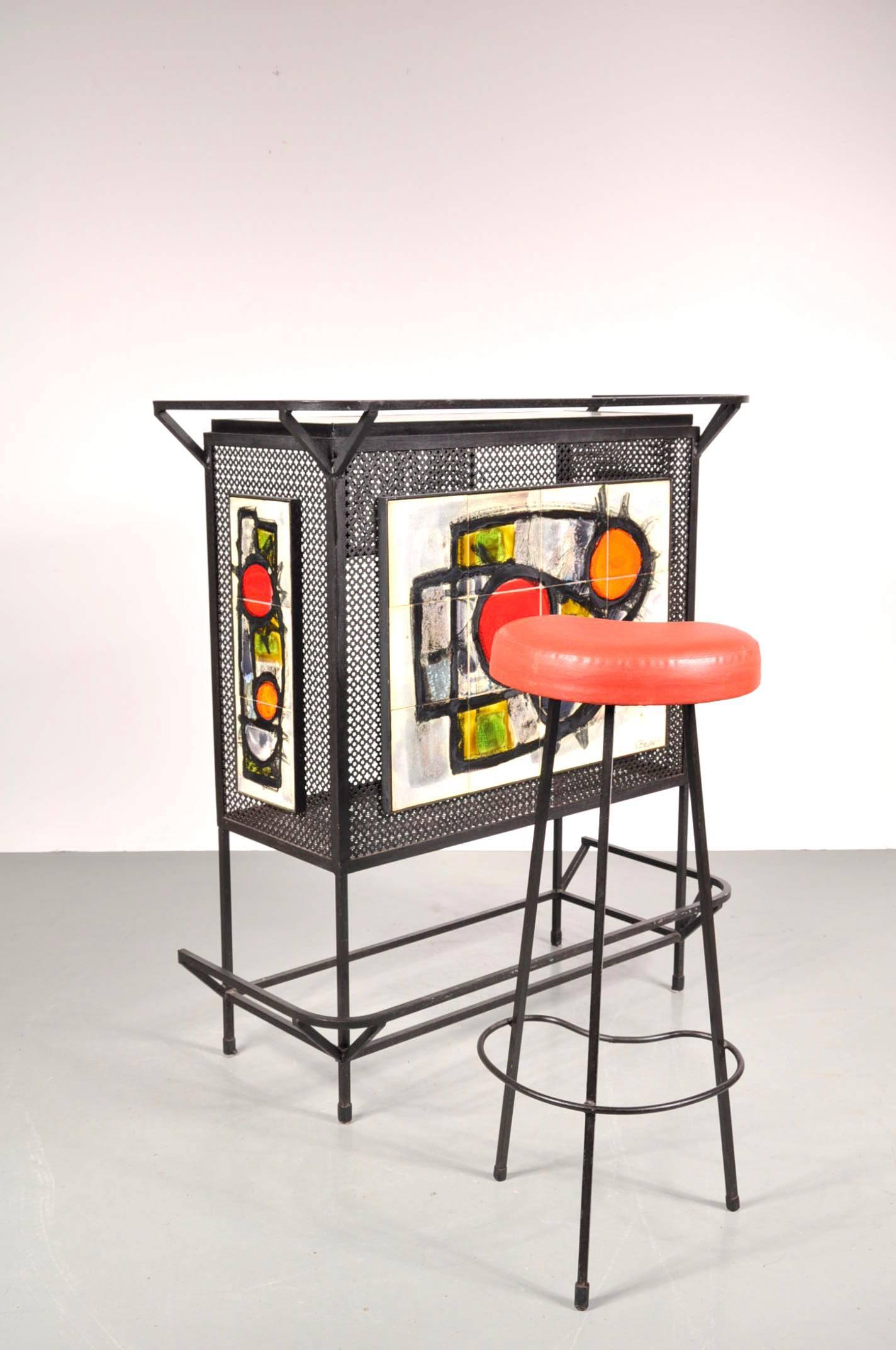 Stunning little bar with stool, designed and signed by J. Belarti in Belgium, circa 1950.

The bar and stool are made of black lacquered metal. The sides of the bar made of beautifuly perforated metal and the front has ceramics painted with