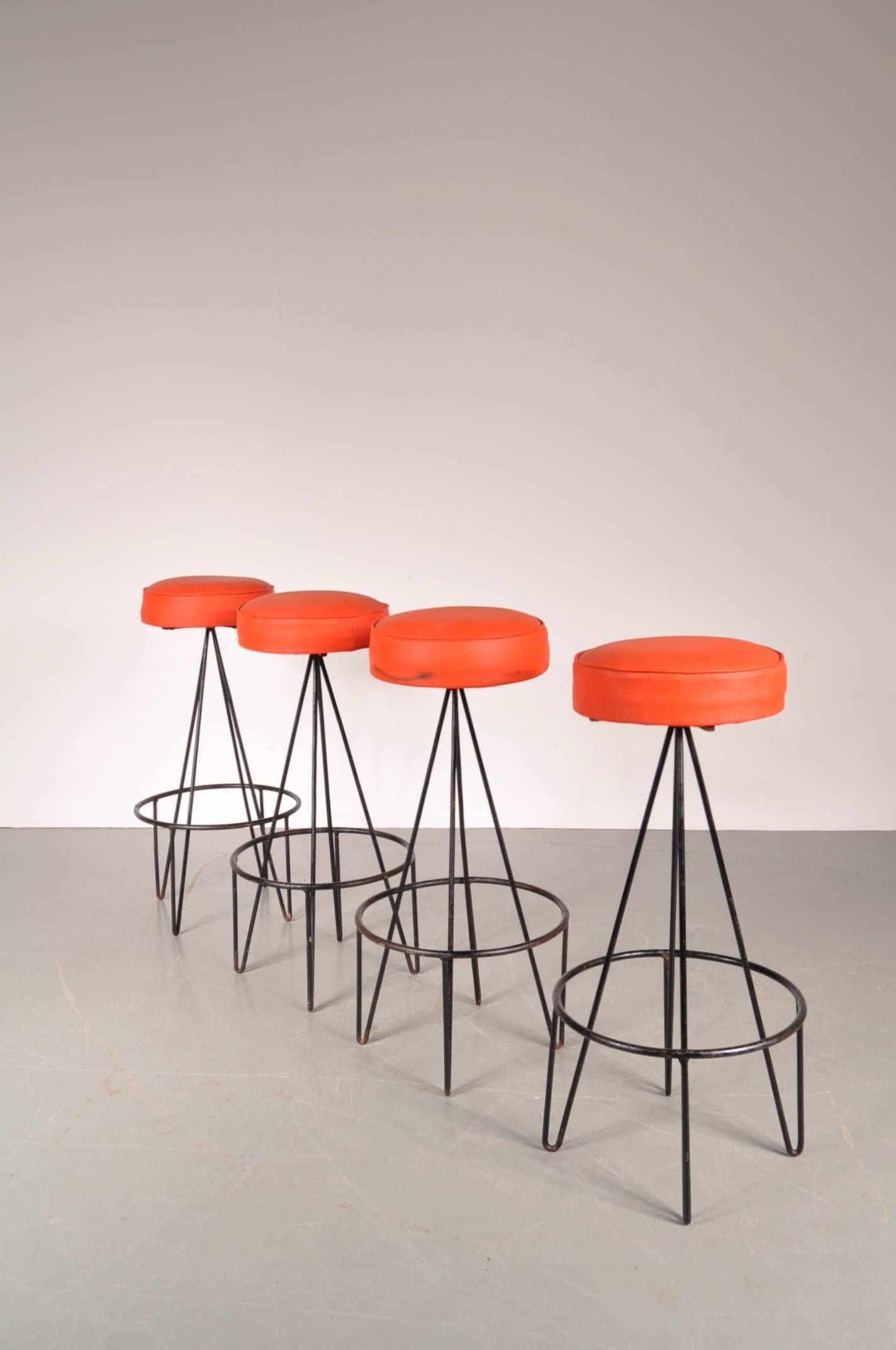 Stunning set of four bar stools designed by Frederick Weinberg in the USA, circa 1950.

The stools are made of high quality black lacquered metal with a red skai upholstered seat. The legs are bent and connected by a black metal ring, giving it a