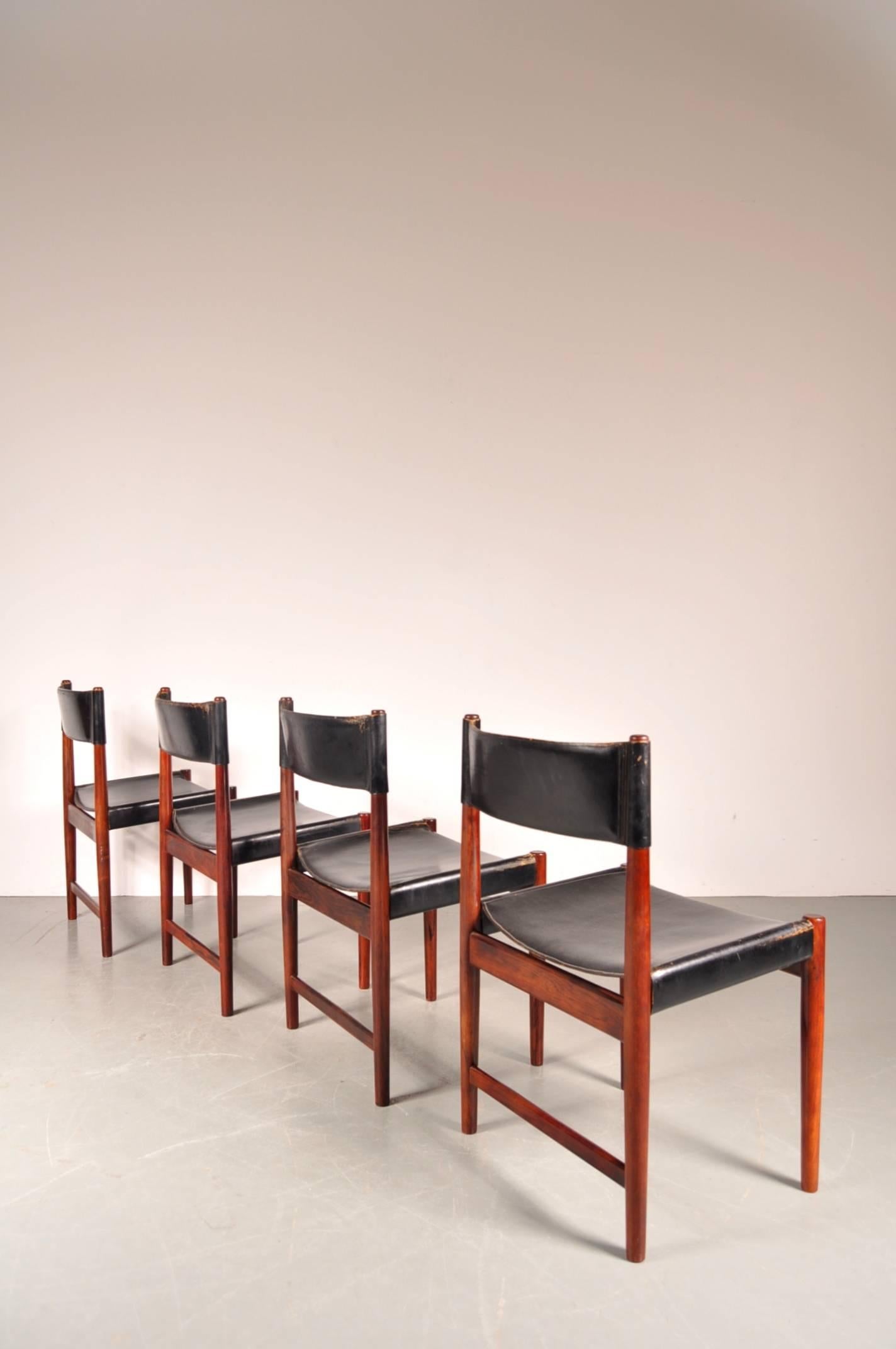 Very rare set of four dining chairs designed by Arne Vodder, manufactured by Sibast in Denmark, circa 1950. 

These eye-catching chairs are made of thick black saddle leather on a beautiful quality rosewood base. They are a rare find, and