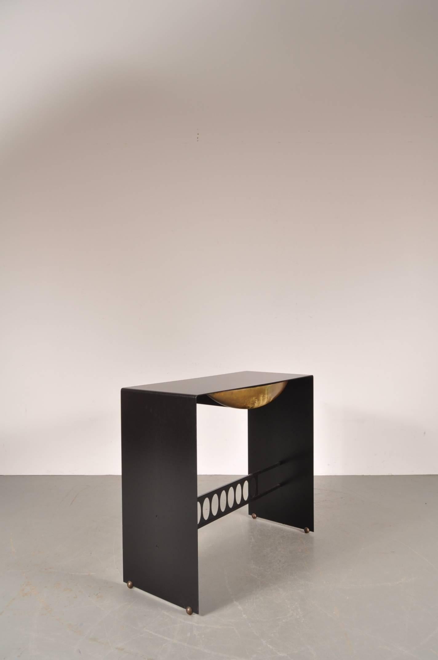 Luxurious metal with brass console table, manufactured in Italy, circa 1970.

This eye-catching piece is almost completely made of beautiful crafted black metal. It is beautifuly finished with a brass drawer and small brass leg-ends lifting the